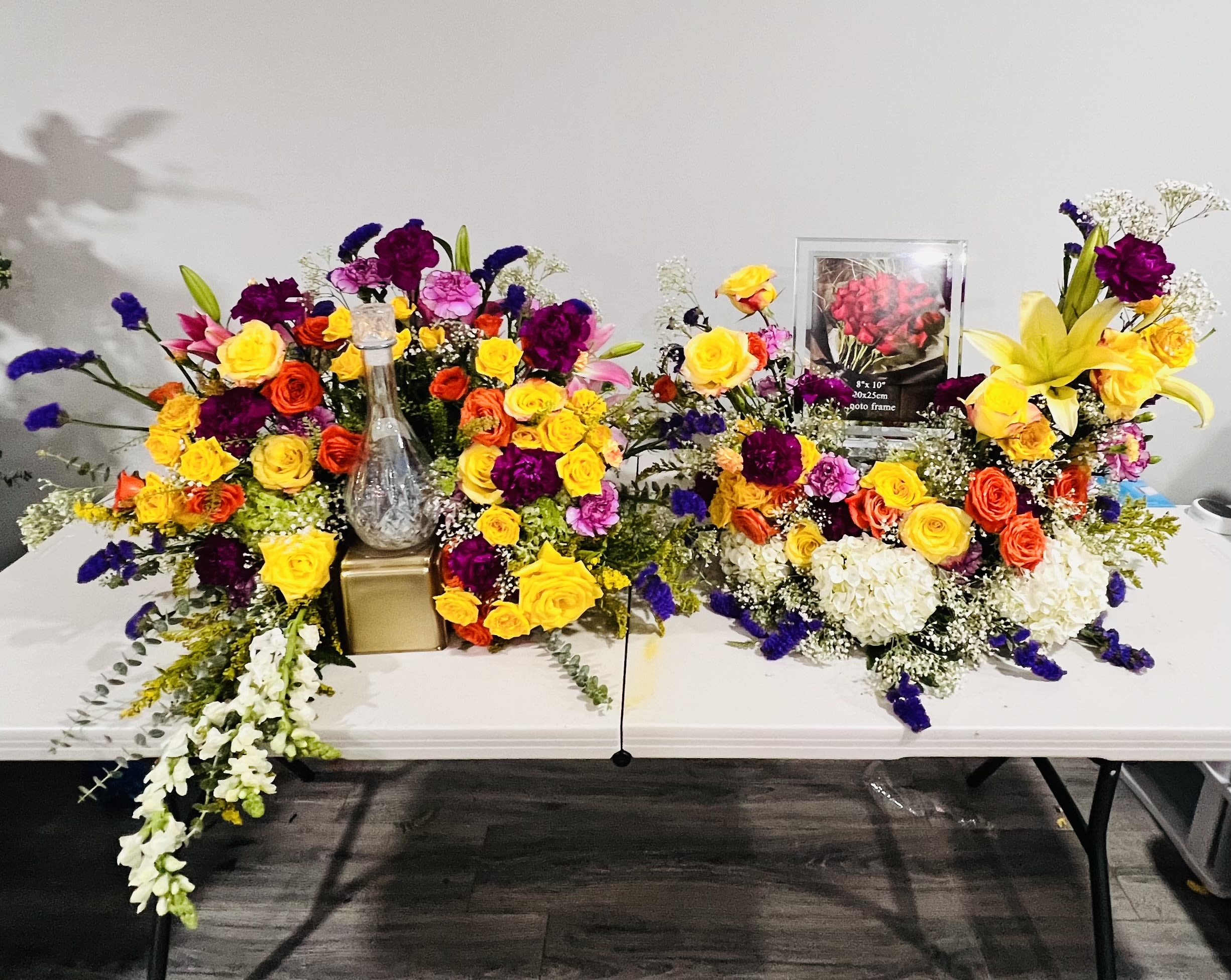 Colorful floral arrangements with roses, lilies, and carnations on a table