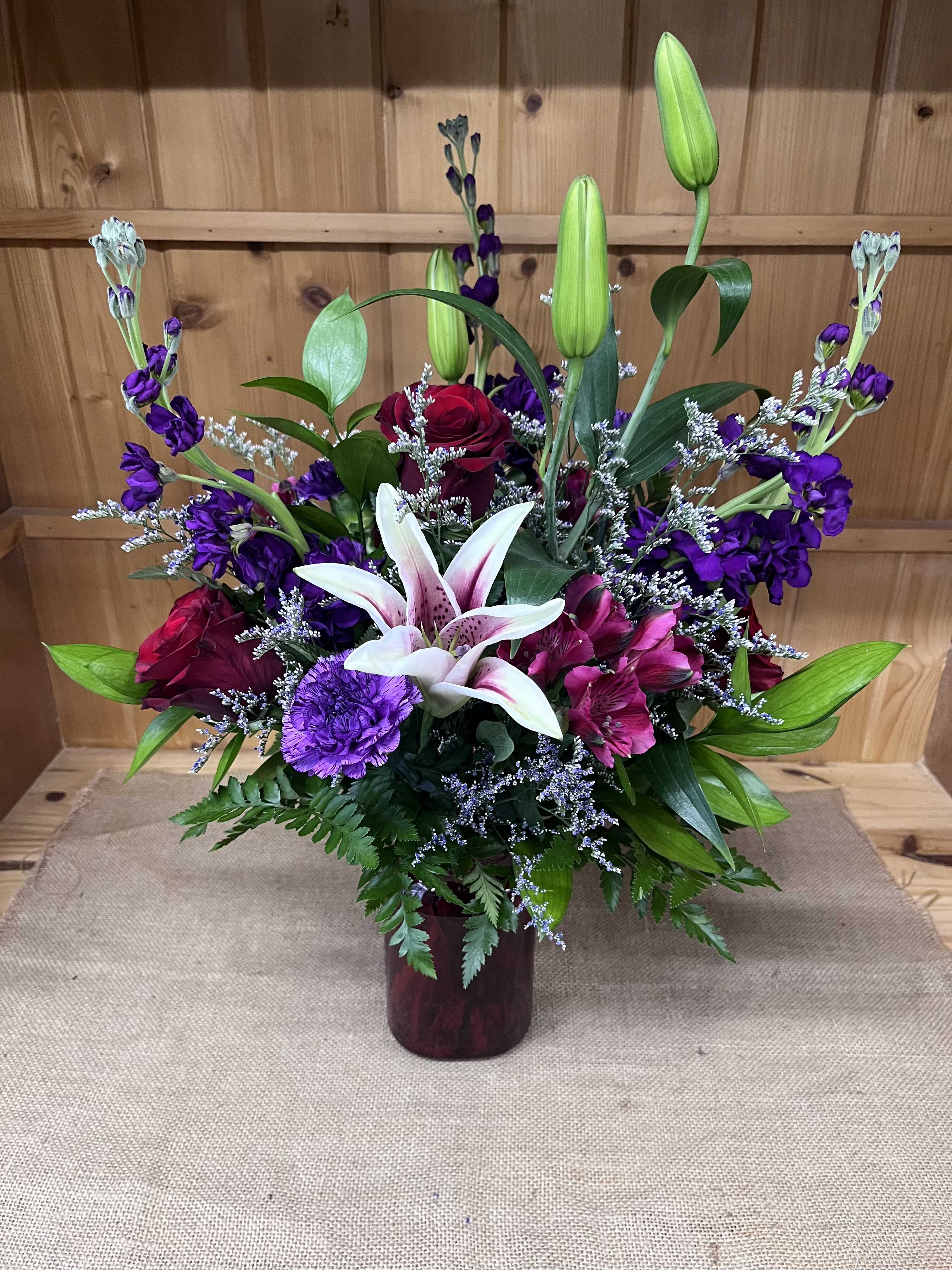 Mixed bouquet with lilies, roses, and purple flowers in a vase