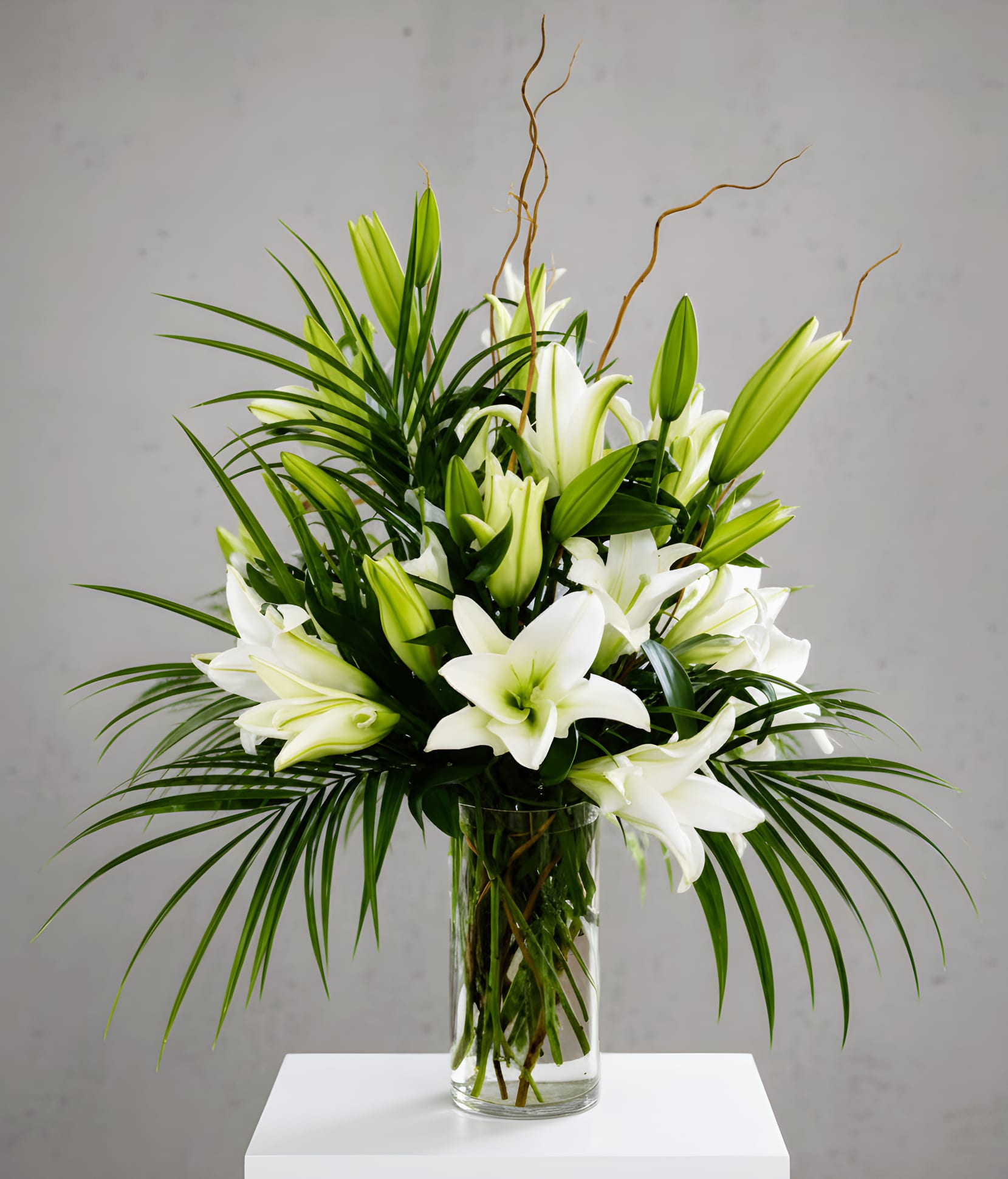 Elegant White Lily Bouquet - Graceful and timeless, our Elegant White Lily Bouquet showcases premium white Oriental lilies arranged with lush tropical greenery in a sleek clear glass vase. Featuring a beautiful mix of fragrant open blooms and fresh buds that continue to bloom over time, this sophisticated arrangement brings lasting beauty and elegance to any space. Perfect for expressing sympathy, celebrating anniversaries, sending get well wishes, or simply sharing a thoughtful gesture, this classic bouquet makes a memorable gift for any occasion.  Flowers Included: White Oriental Lilies Assorted Premium Greenery  Perfect For: Sympathy &amp; Funeral Get Well Thinking of You Anniversary Birthday Thank You Housewarming Just Because