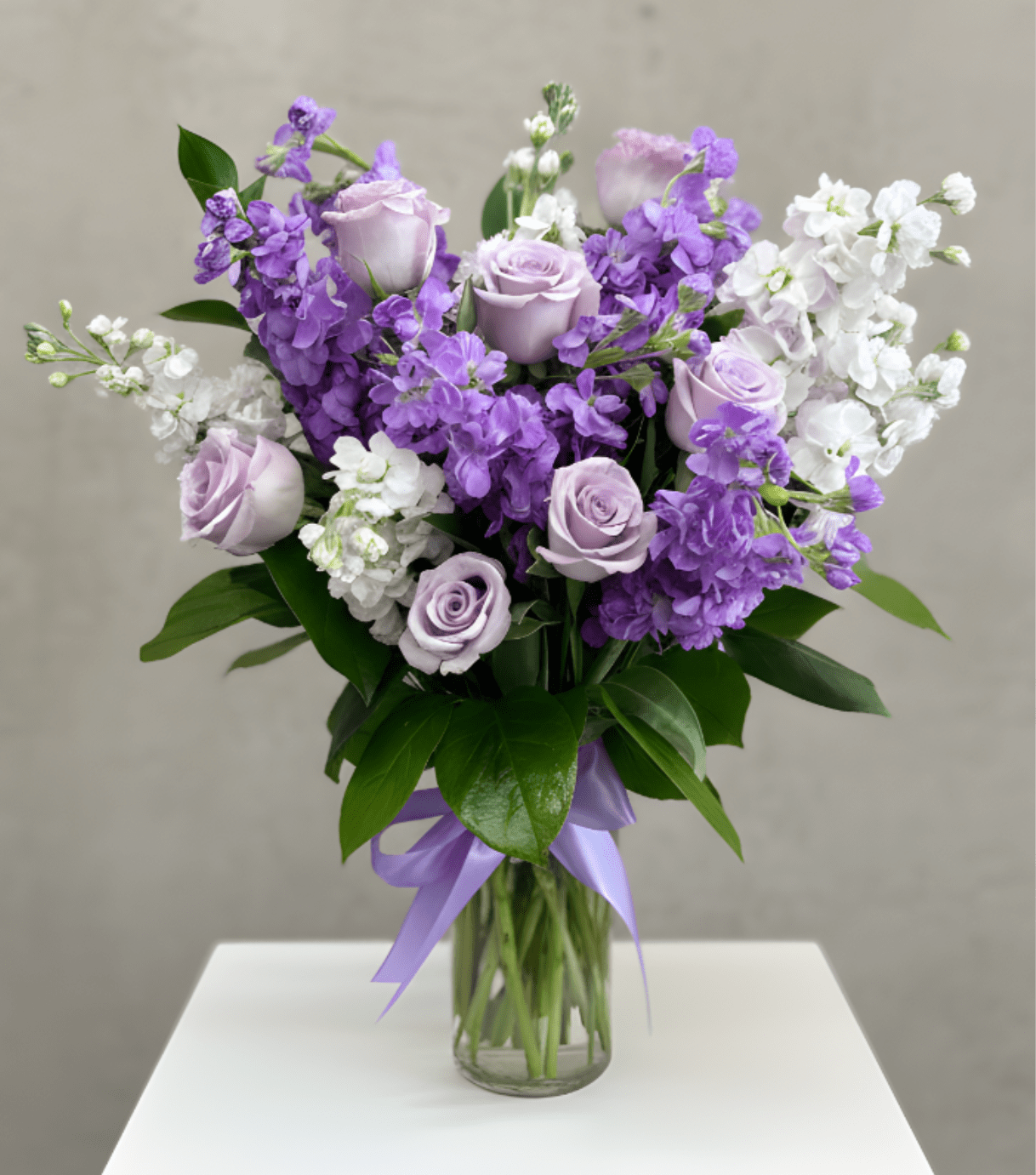 Lavender Garden - A soft and elegant arrangement featuring delicate lavender looms. Designed in a clear glass vase and finished with a satin lavender ribbon, this bouquet brings a sense of calm, beauty, and grace to any occasion. Perfect for Mother's Day, expressing sympathy, celebrating special moments, or simply brightening someone’s day with timeless charm.