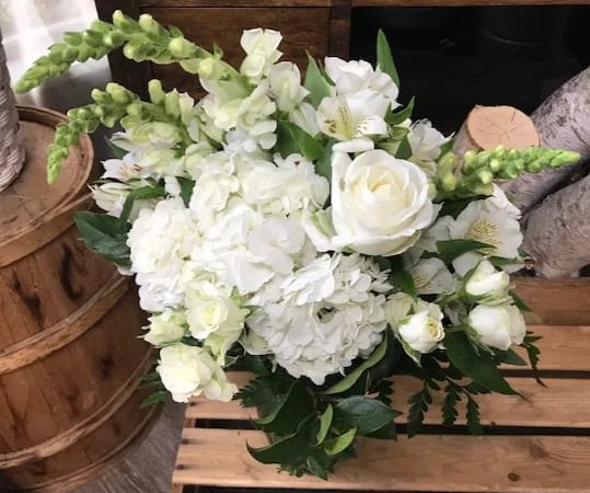 Love's Embrace - This monochromatic bouquet features white Roses, Spray Roses, Snapdragons, Hydrangea and Alstroemeria. Perfect for any occasion!