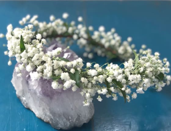 White flower crown resting on a purple crystal