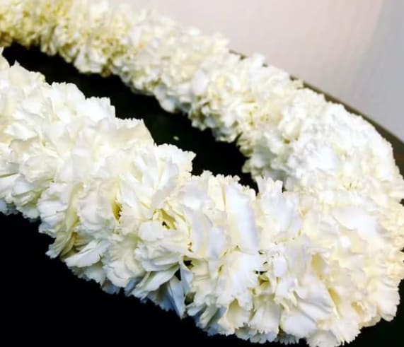 White floral lei on a dark surface