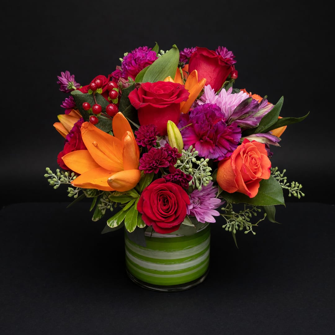 Colorful mixed bouquet in a green striped glass vase