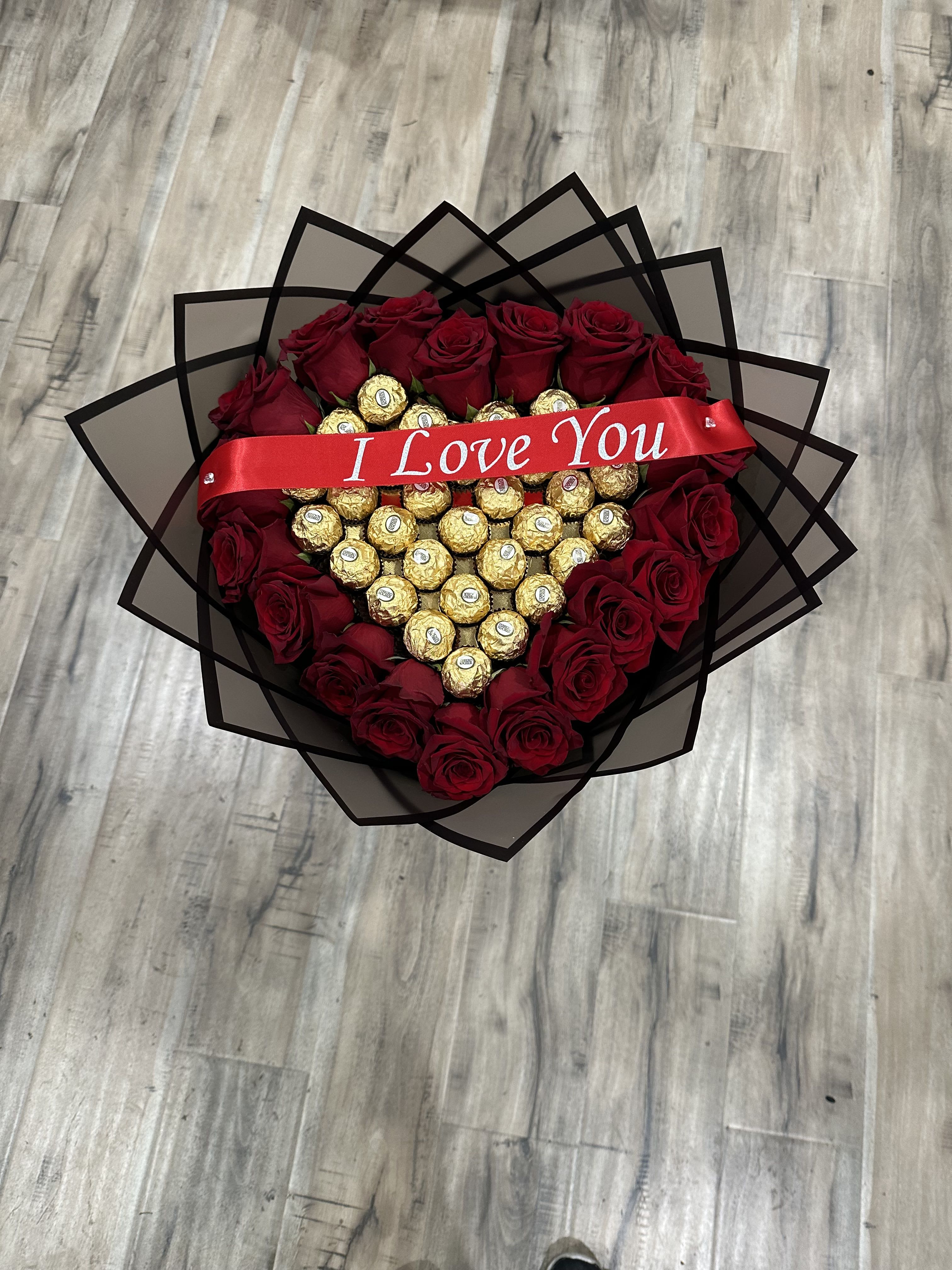 Heart-shaped bouquet of red roses and gold chocolates with an "I Love You" ribbon