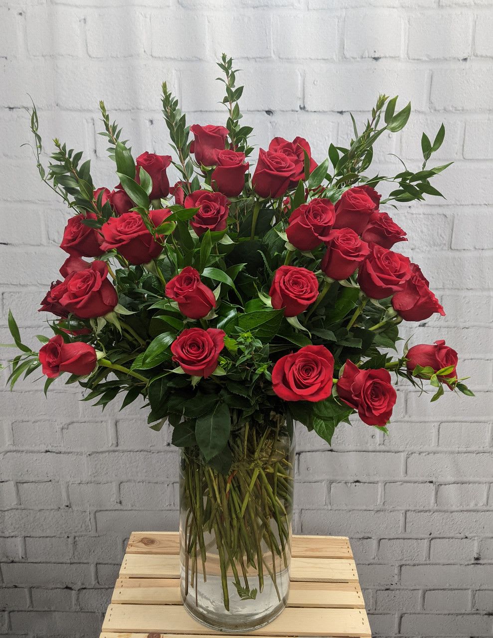 Red roses arranged in a clear glass vase