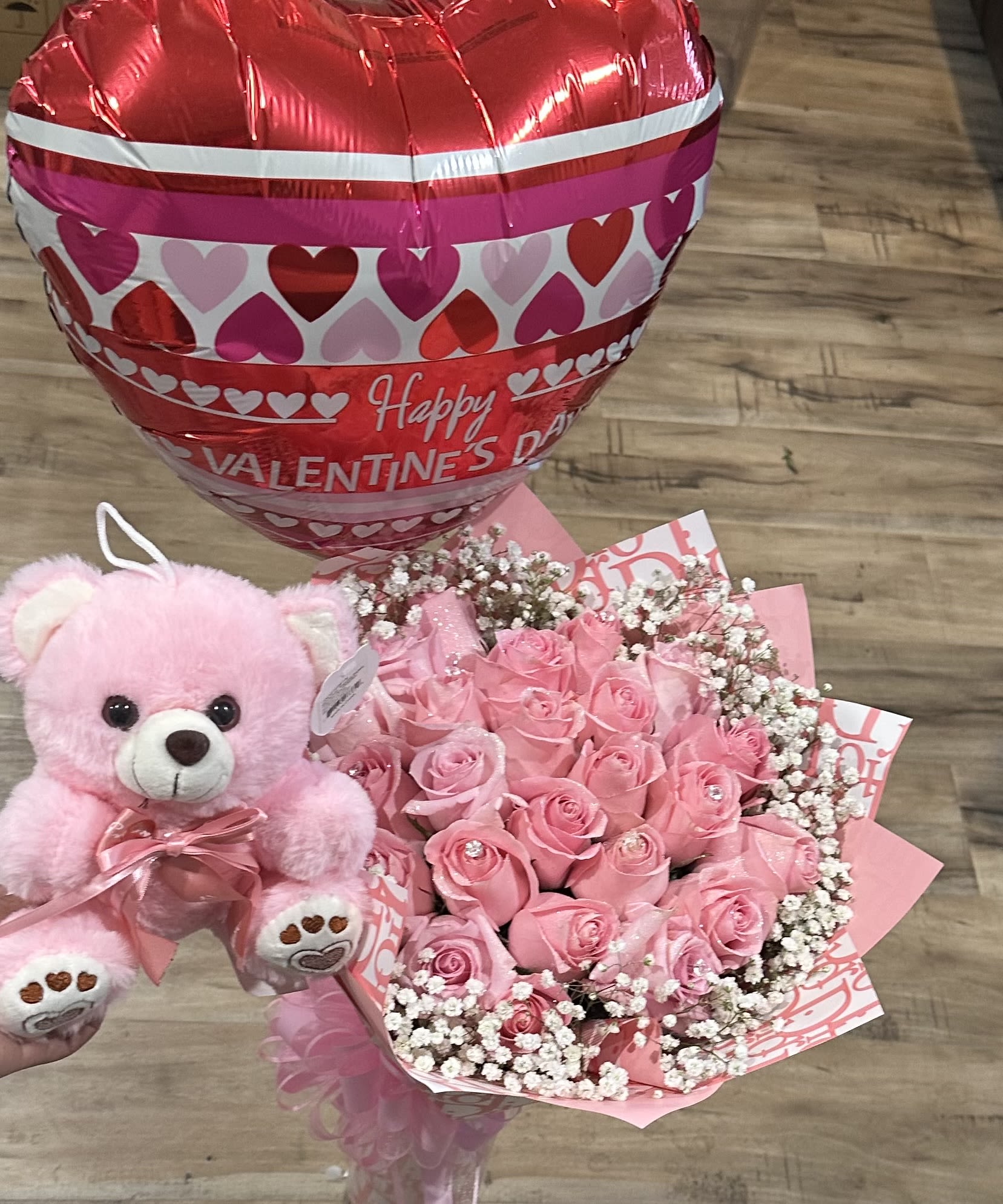 Pink rose bouquet with a teddy bear and heart-shaped Valentine balloon