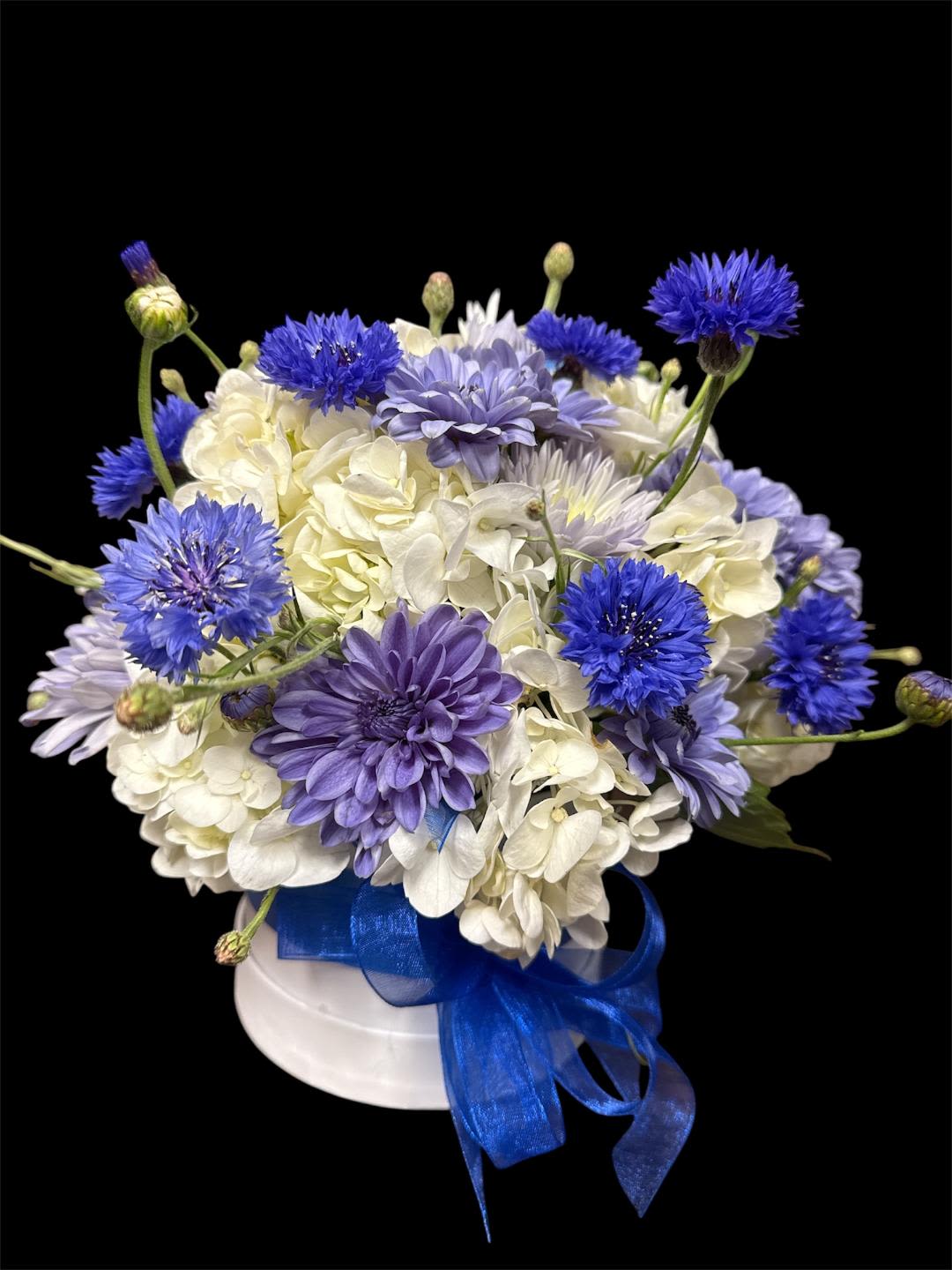 Blue and white bouquet in a white hat box with a blue ribbon
