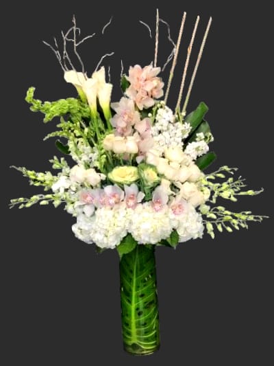 Tall white and blush floral arrangement in a green vase
