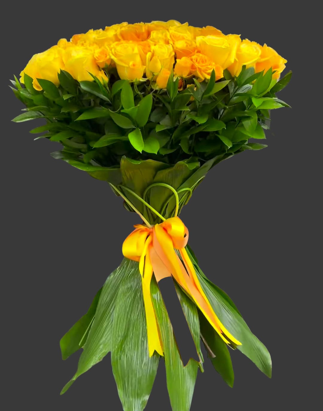 Bouquet of yellow roses wrapped with green leaves and a yellow ribbon