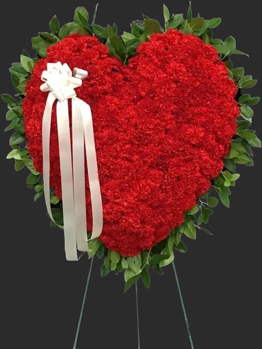 Heart-shaped red floral wreath with a white ribbon bow
