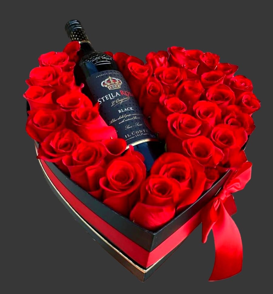 Heart-shaped box of red roses with a wine bottle in the center