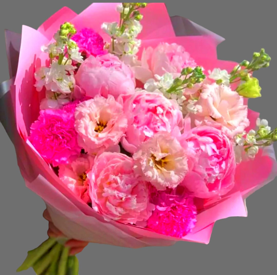 Pink bouquet of peonies and carnations wrapped in bright pink paper