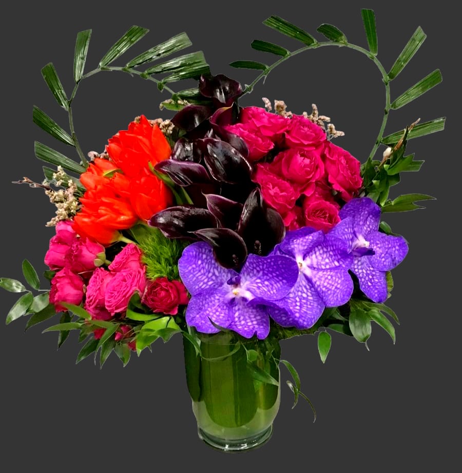 Colorful bouquet with roses, orchids, and tulips in a glass vase