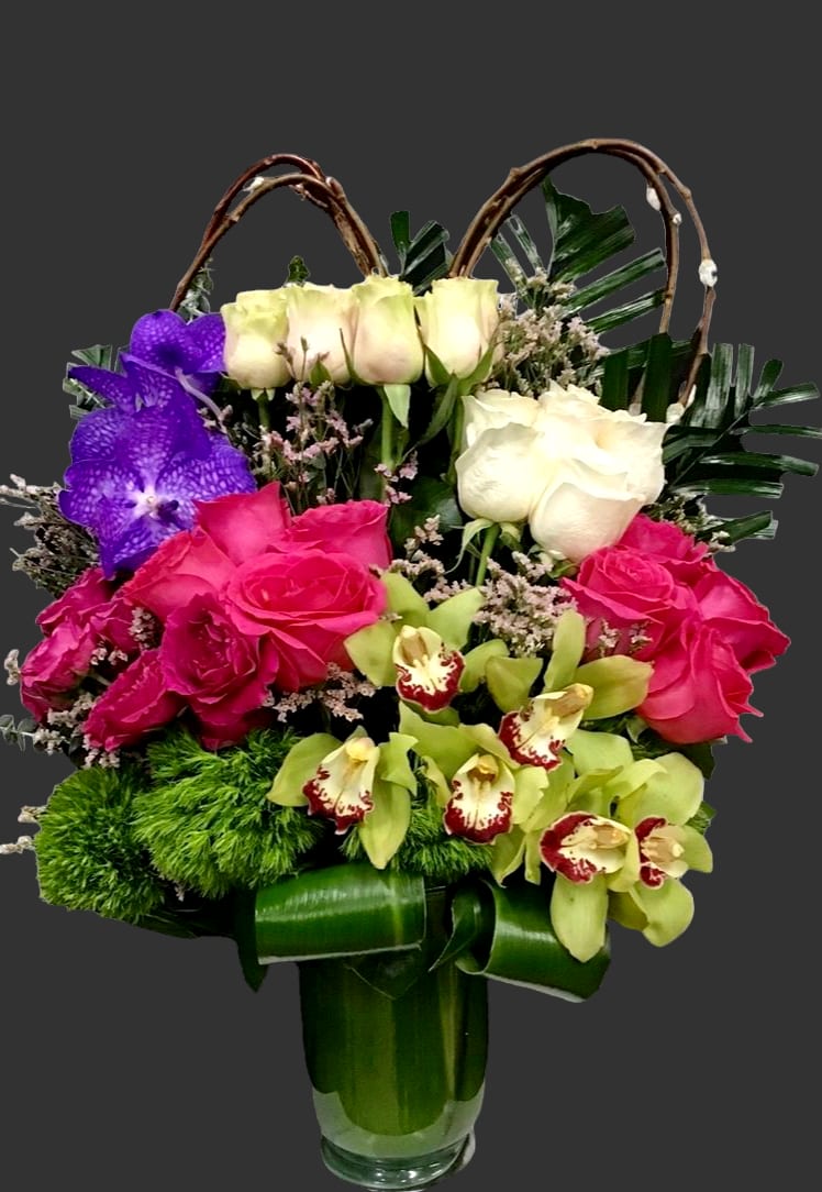 Colorful floral arrangement in a glass vase with roses and orchids