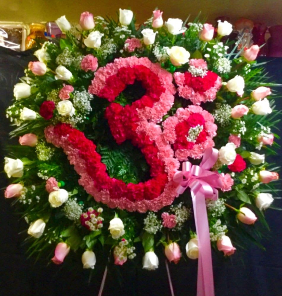 Large floral wreath with pink and white roses and a pink ribbon bow