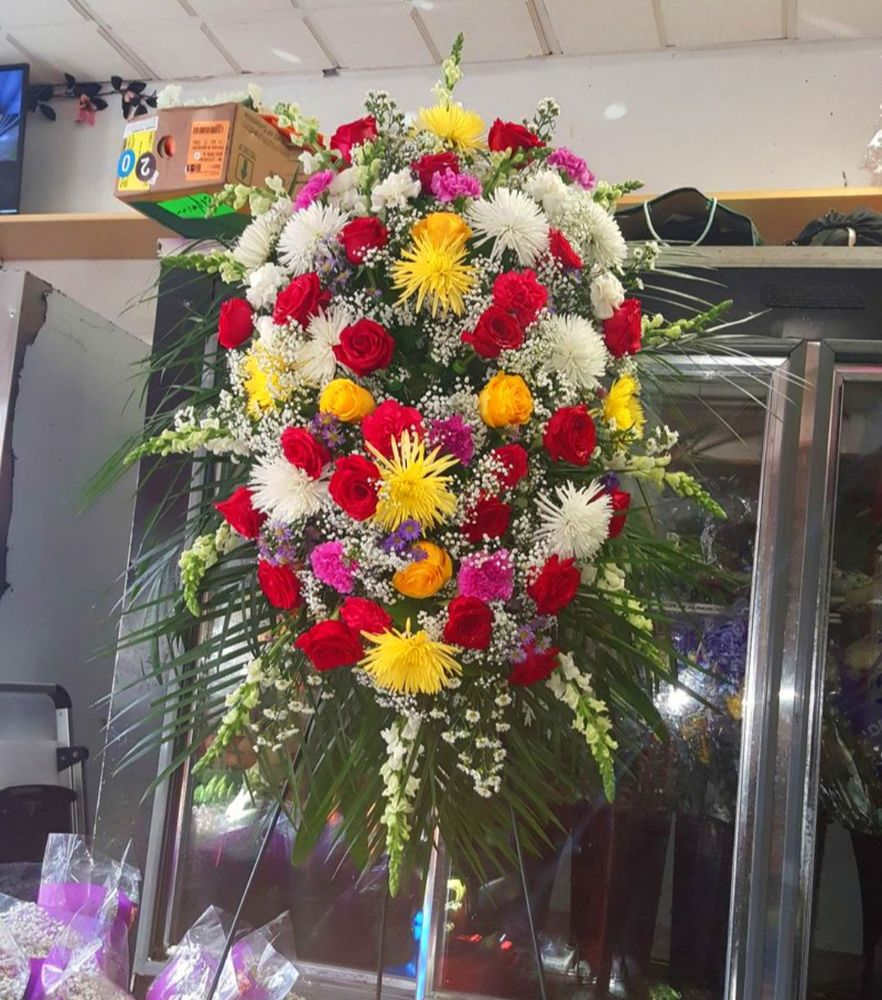 Large standing floral spray with red, white, yellow, and pink flowers