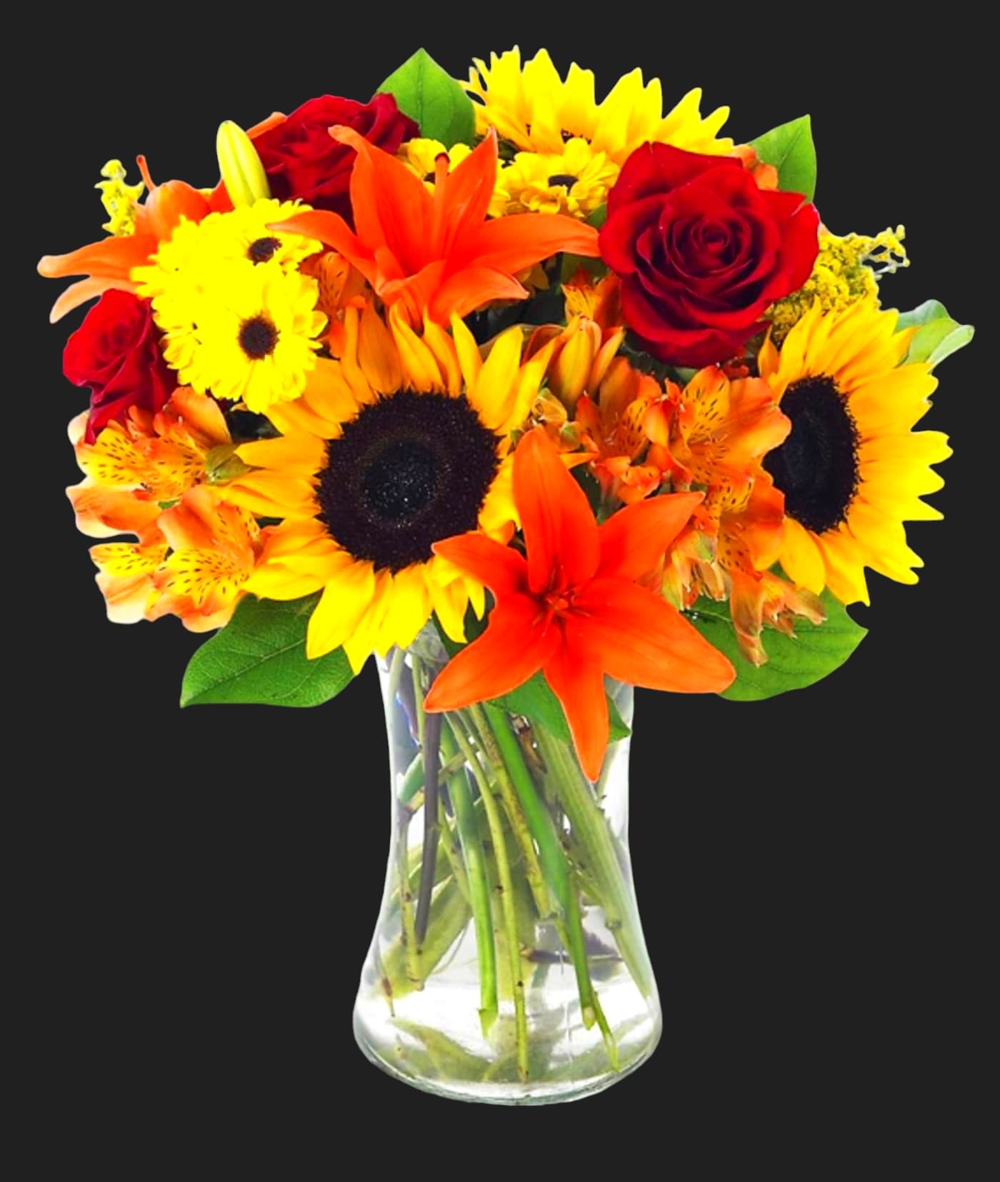 Bouquet of sunflowers, red roses, and orange lilies in a clear glass vase