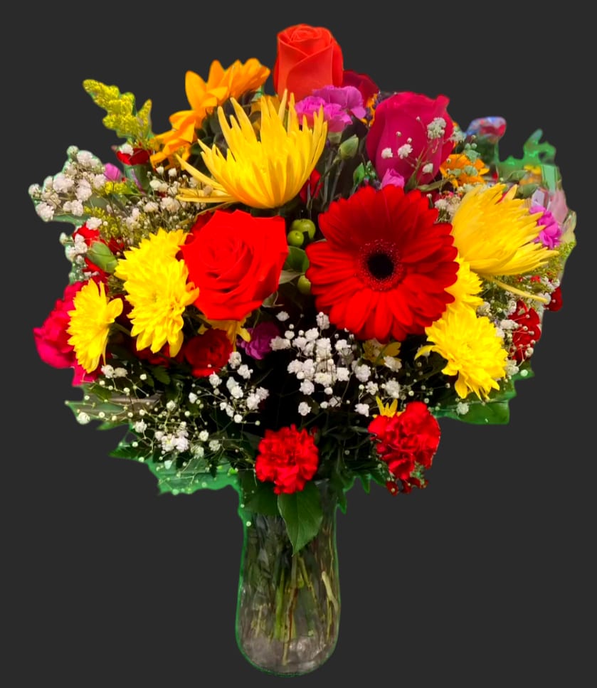 Mixed bouquet of red, yellow, and pink flowers in a glass vase