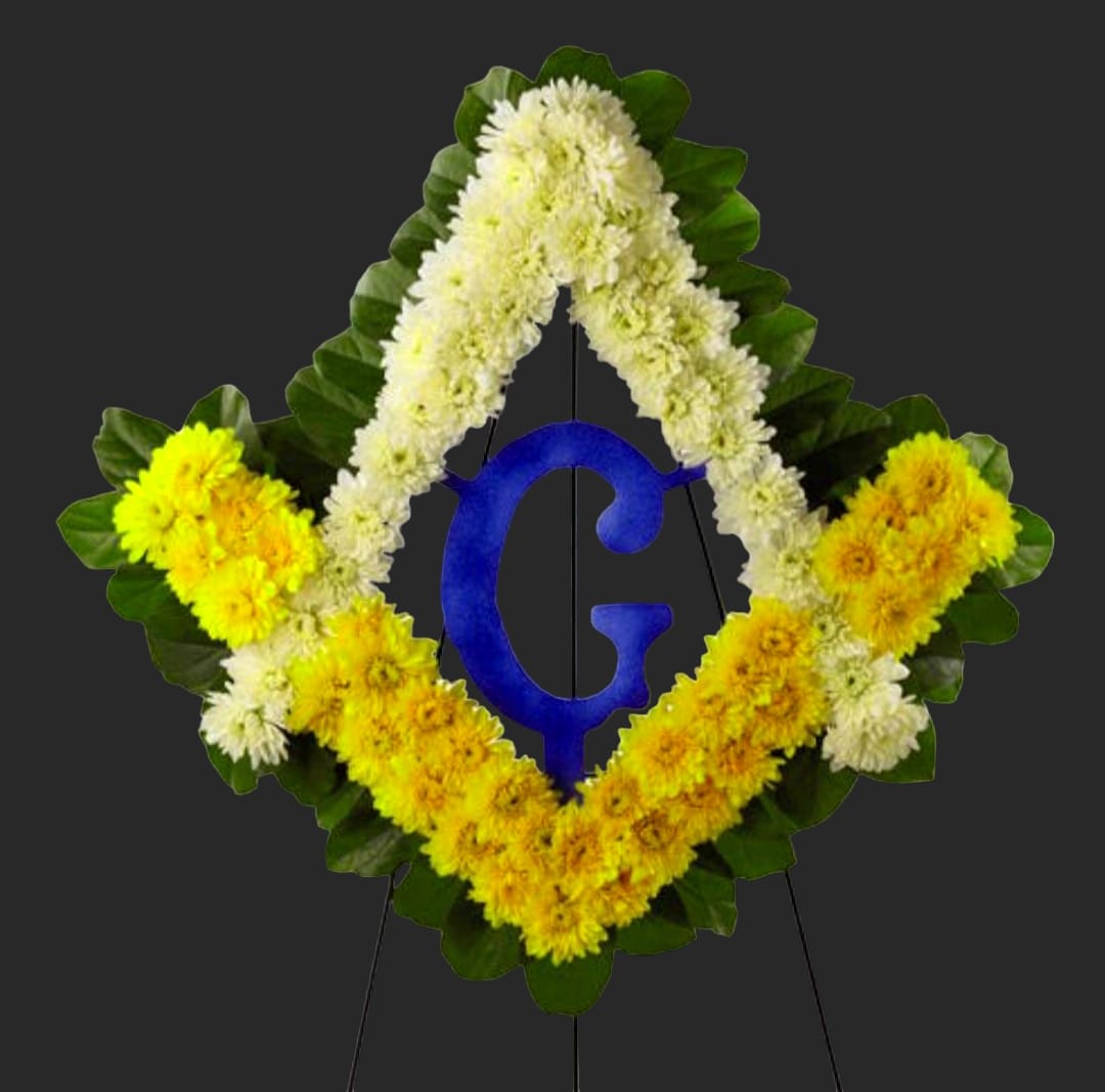Diamond-shaped floral wreath with white and yellow flowers around a blue letter G
