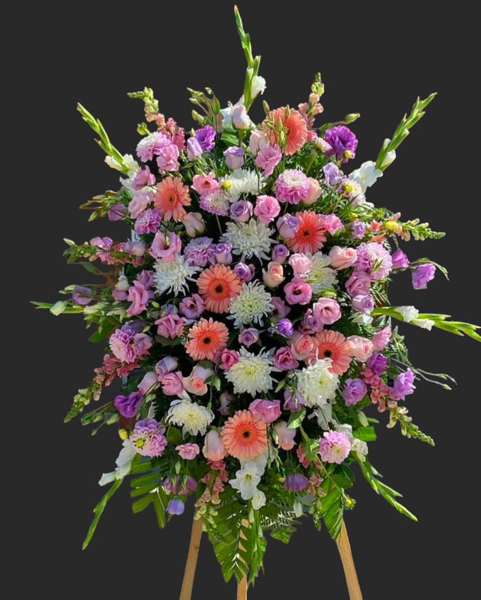 Large standing spray of pink, purple, and white flowers on an easel
