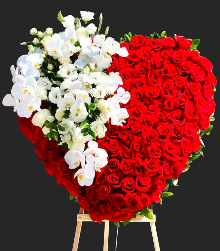 Heart-shaped arrangement of red roses with white orchids