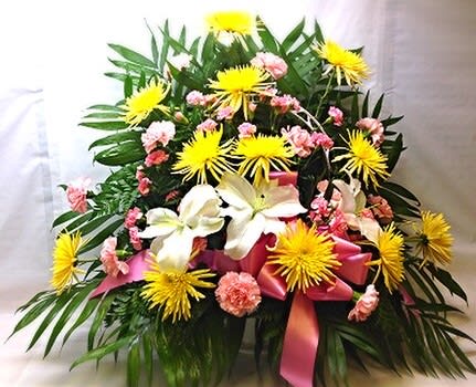 Large floral arrangement with yellow spider mums, white lilies, and pink carnations