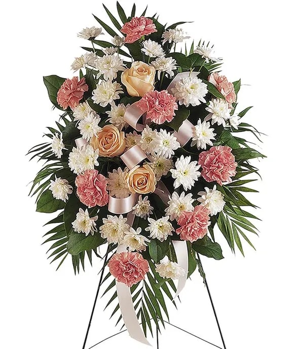 Standing floral spray with pink carnations, white daisies, and peach roses