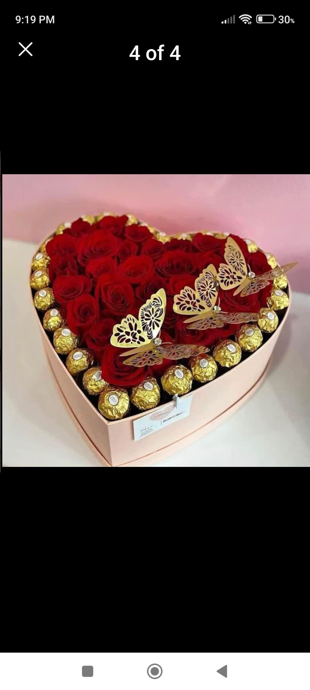 Heart-shaped box of red roses with gold-wrapped chocolates and butterfly decorations
