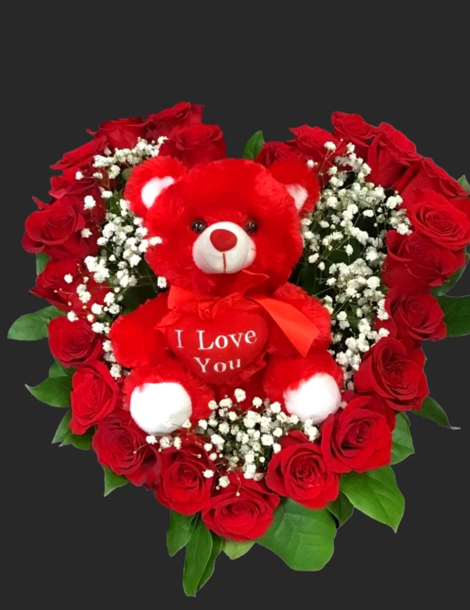 Heart-shaped bouquet of red roses with a red teddy bear in the center