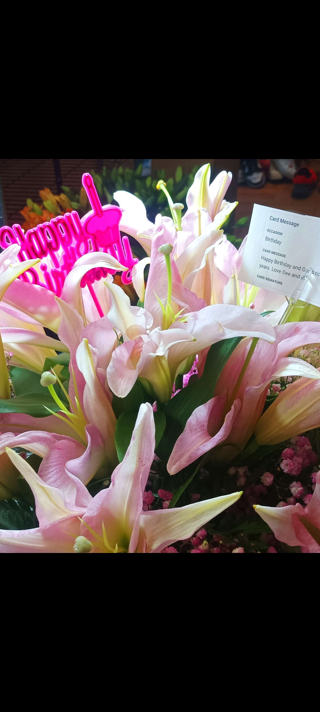 Pink and white lilies with a bright pink Happy Birthday sign