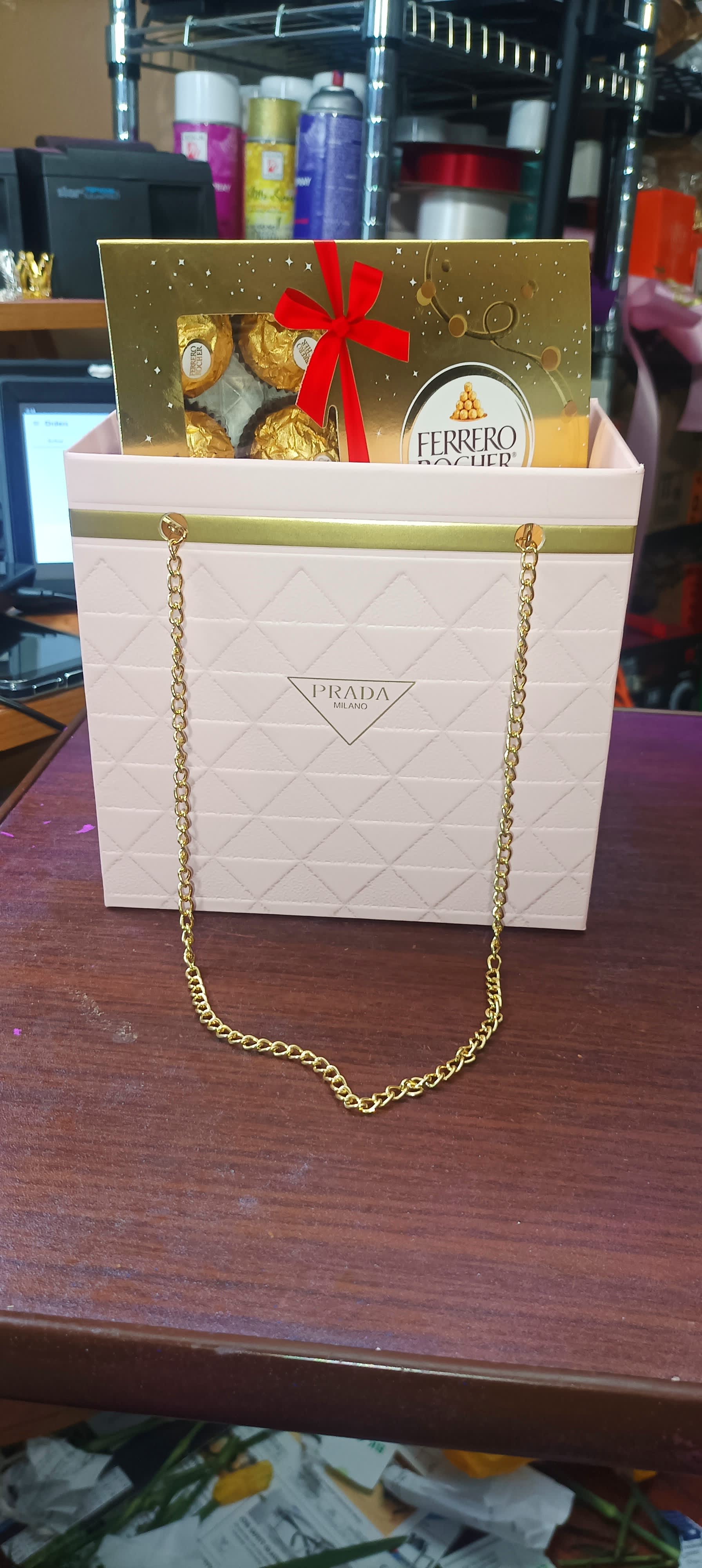 Ferrero Rocher chocolates in a Prada gift bag with a red bow