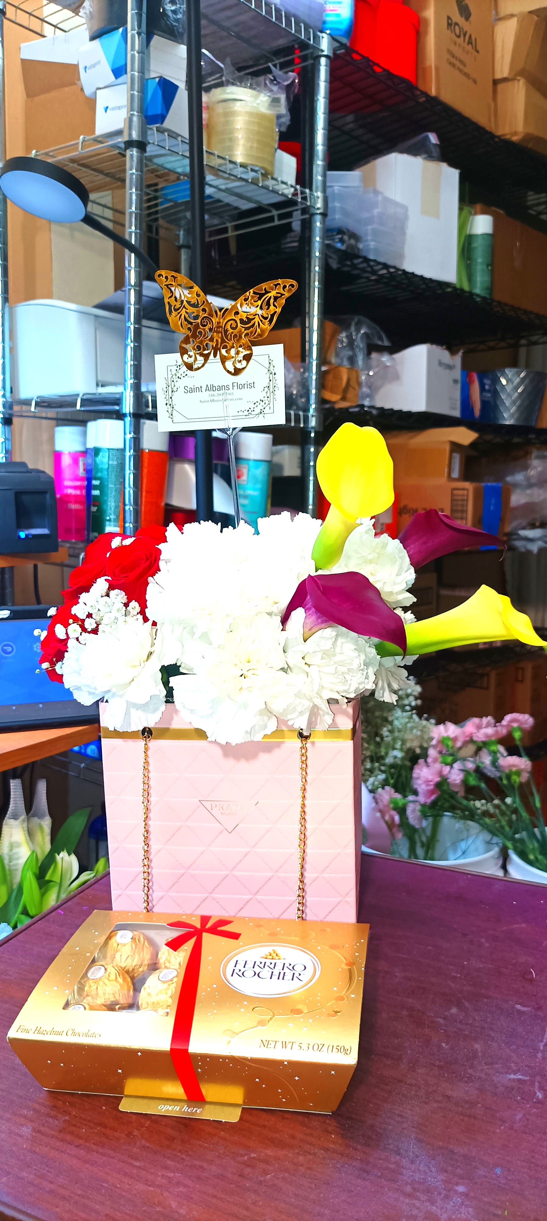 Flower gift box with white and red blooms and a box of chocolates