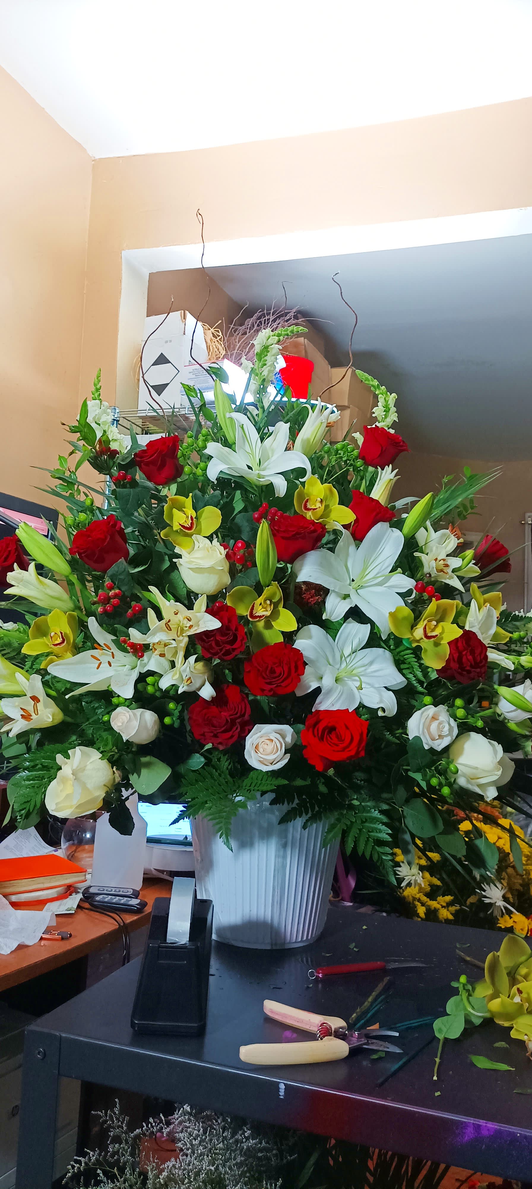 Large mixed bouquet of red and white flowers in a white vase
