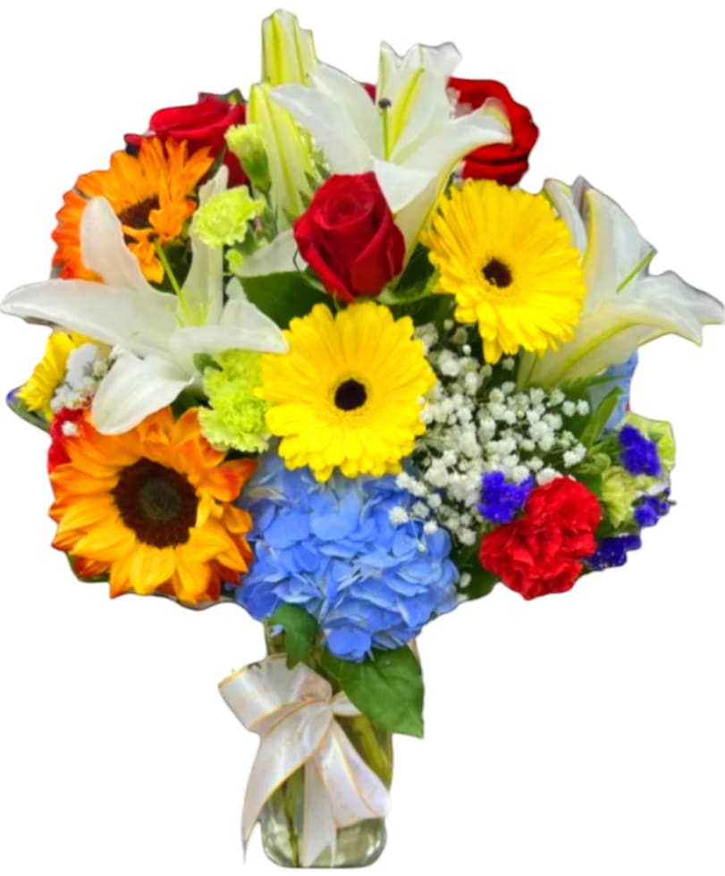 Mixed bouquet with lilies, roses, gerbera daisies, and hydrangea in a glass vase