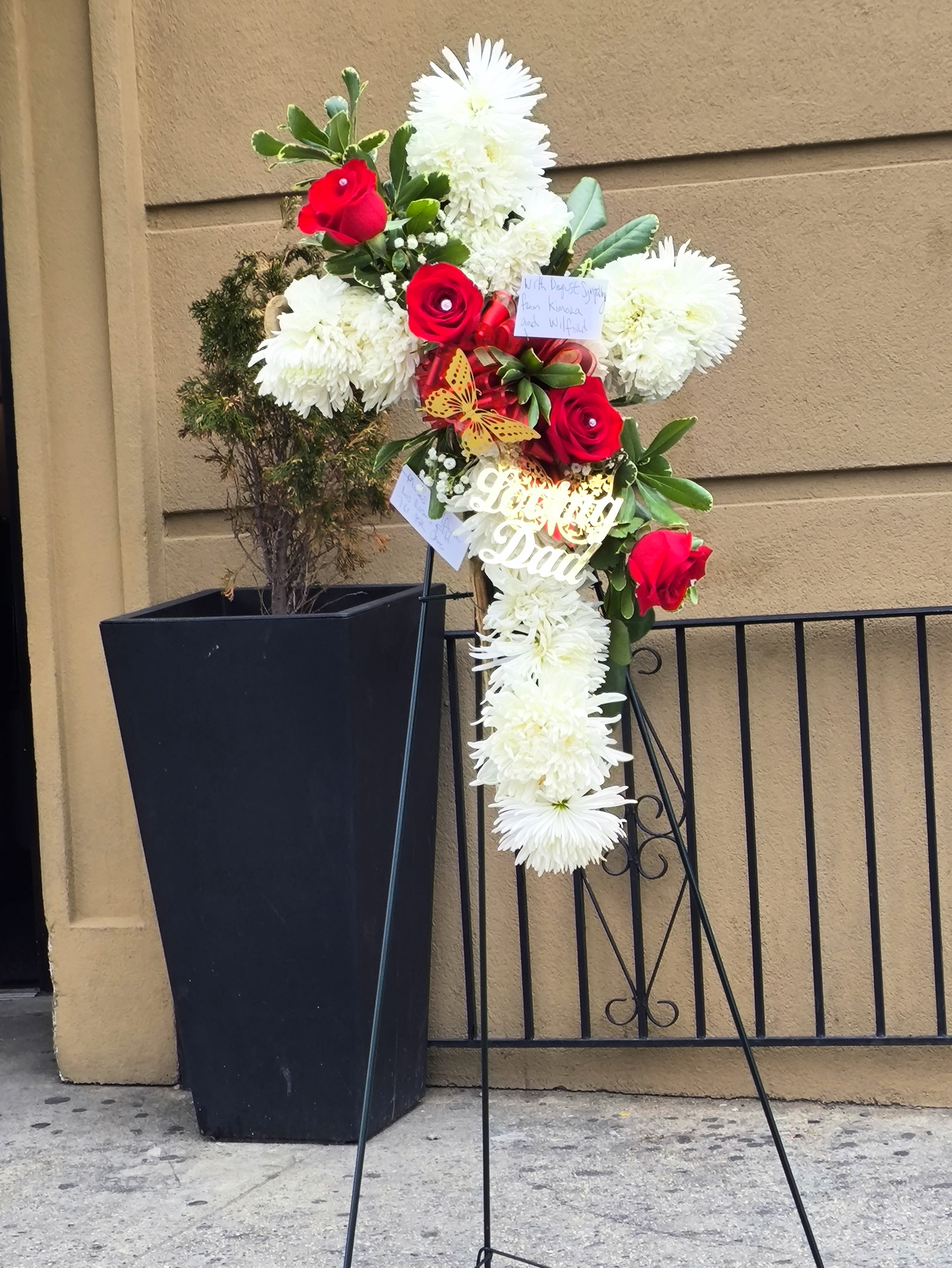 Standing floral tribute with red roses and white chrysanthemums on an easel