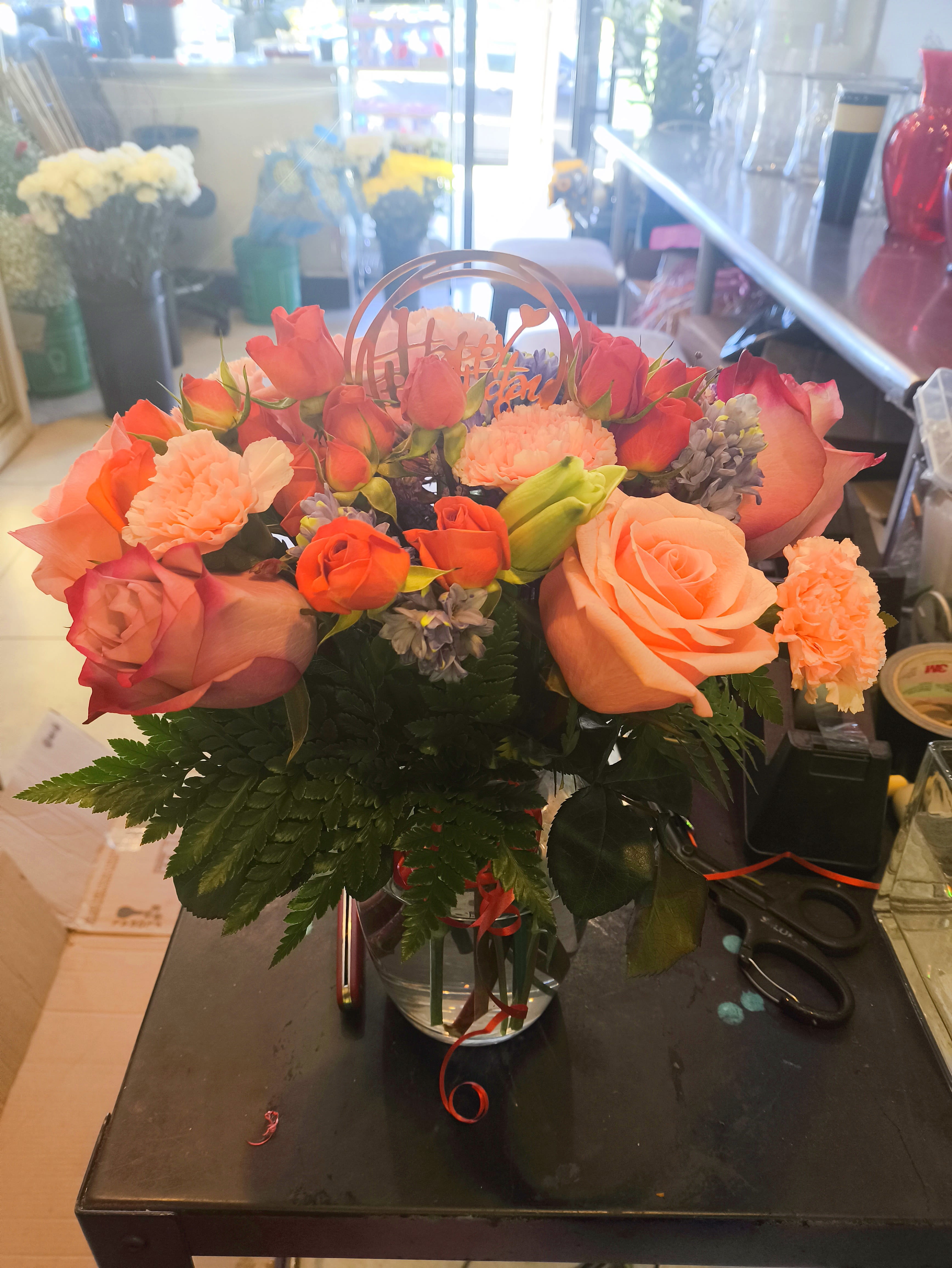 Peach and coral rose bouquet in a clear vase