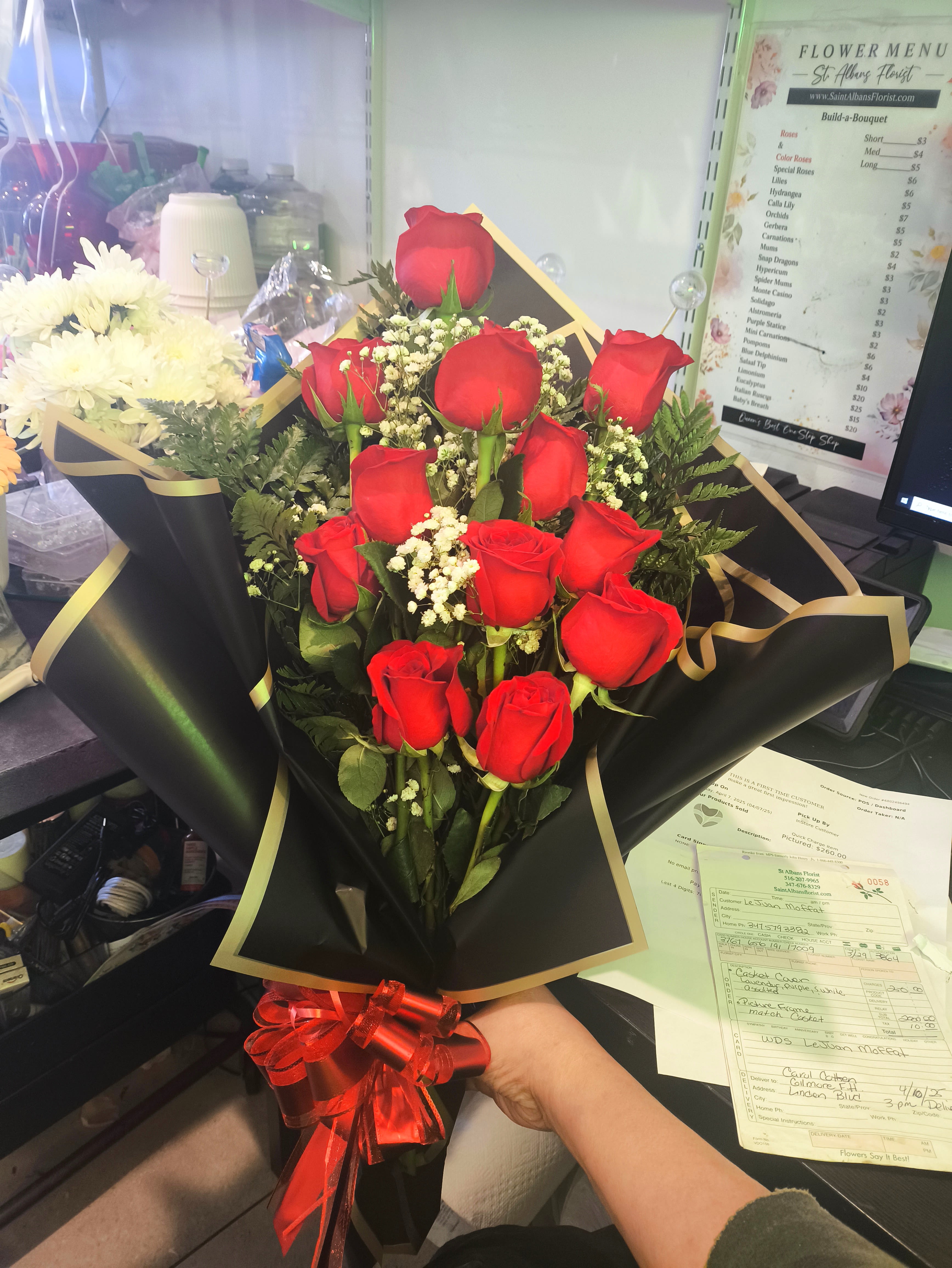 Bouquet of red roses with baby's breath in black wrap and red ribbon