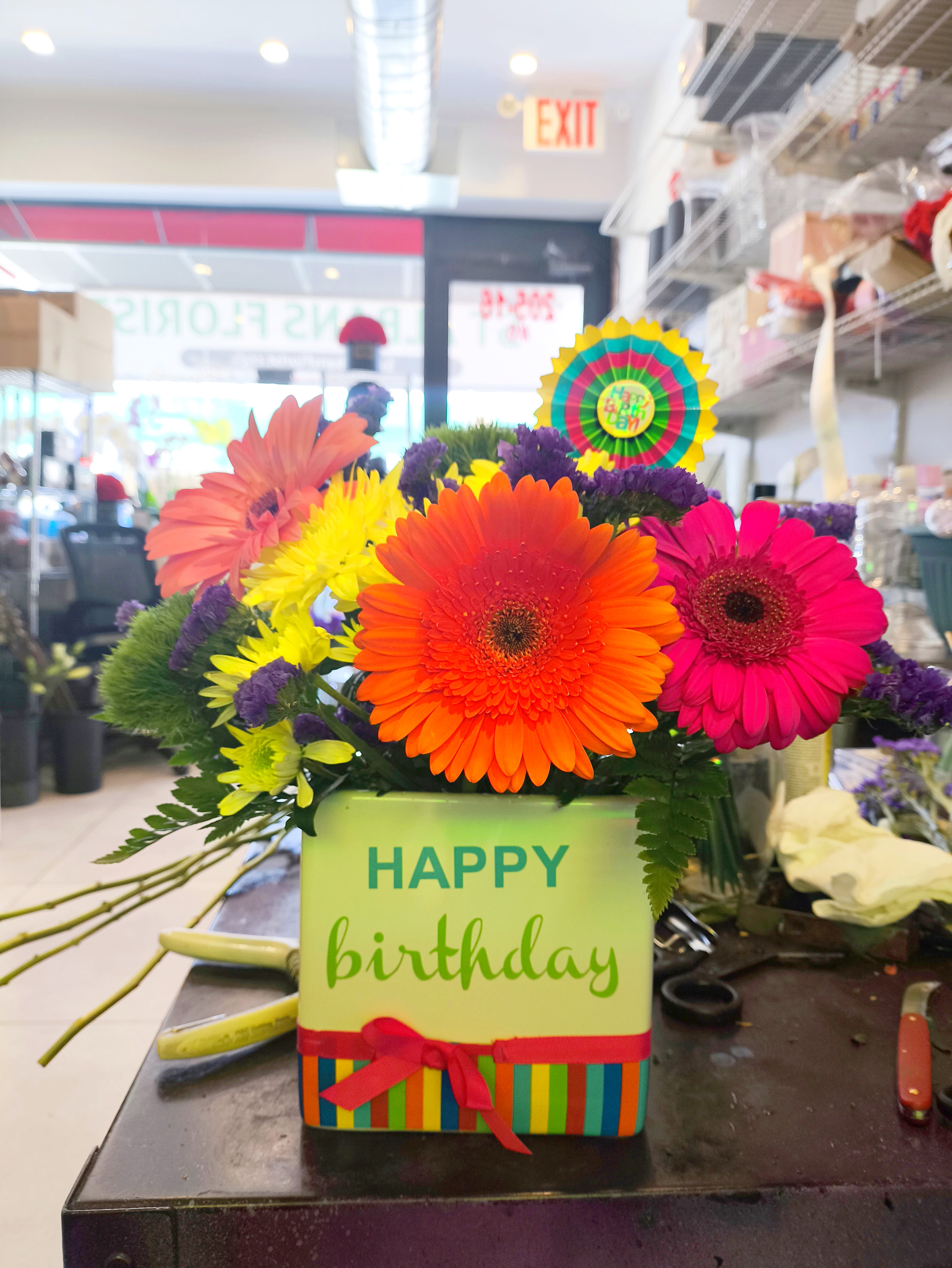 Bright gerbera daisy arrangement in a birthday gift box