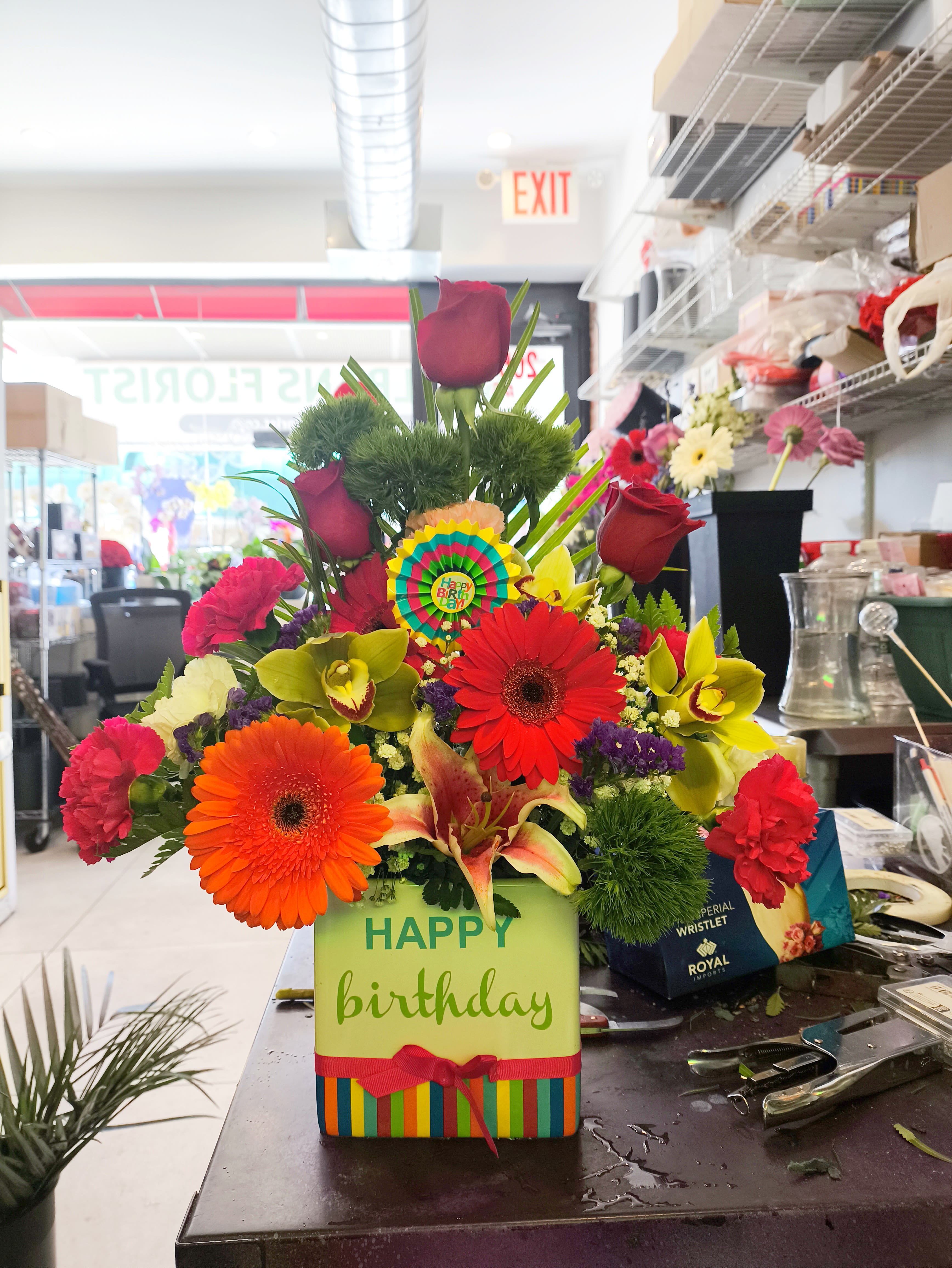 Colorful birthday flower arrangement with gerbera daisies and roses in a gift box
