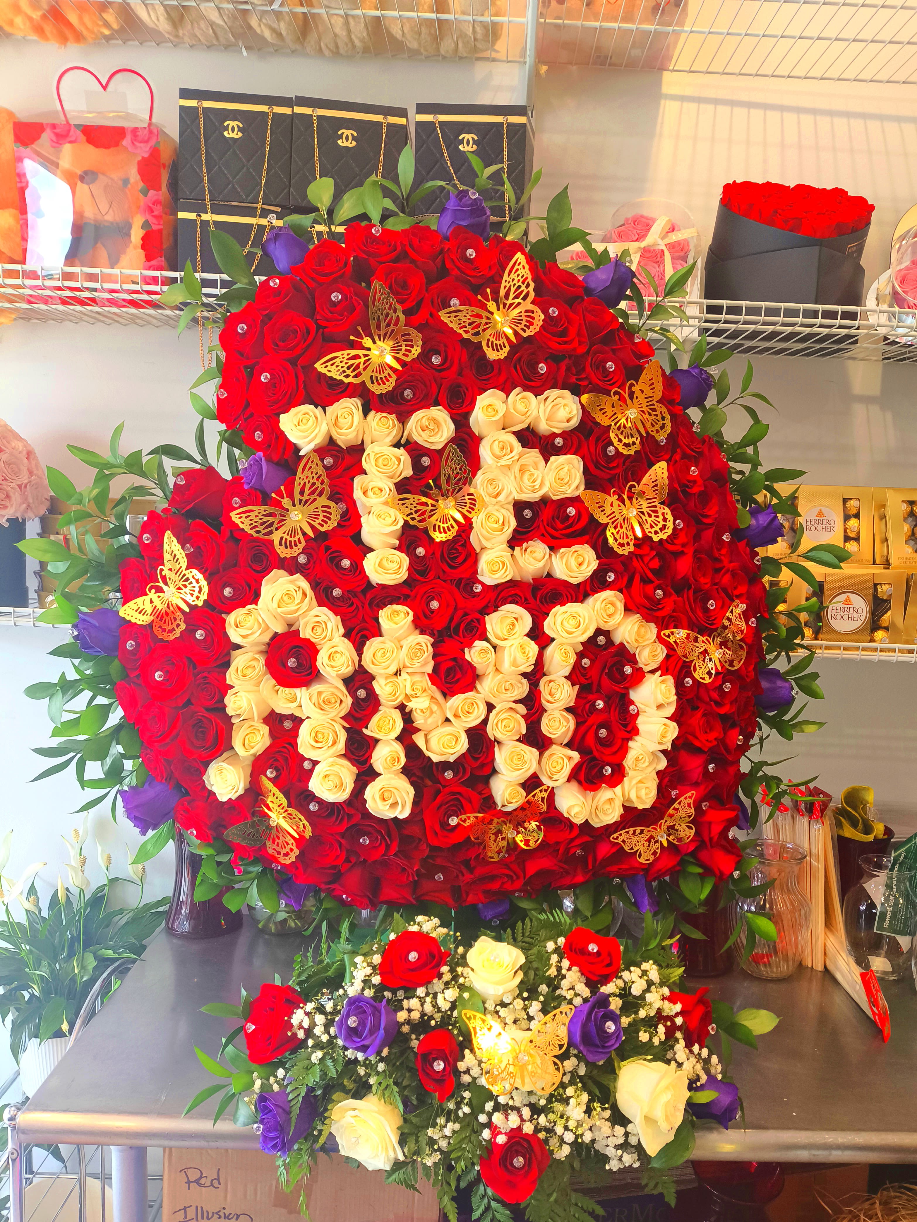 Large heart-shaped rose arrangement with red, cream, and purple roses