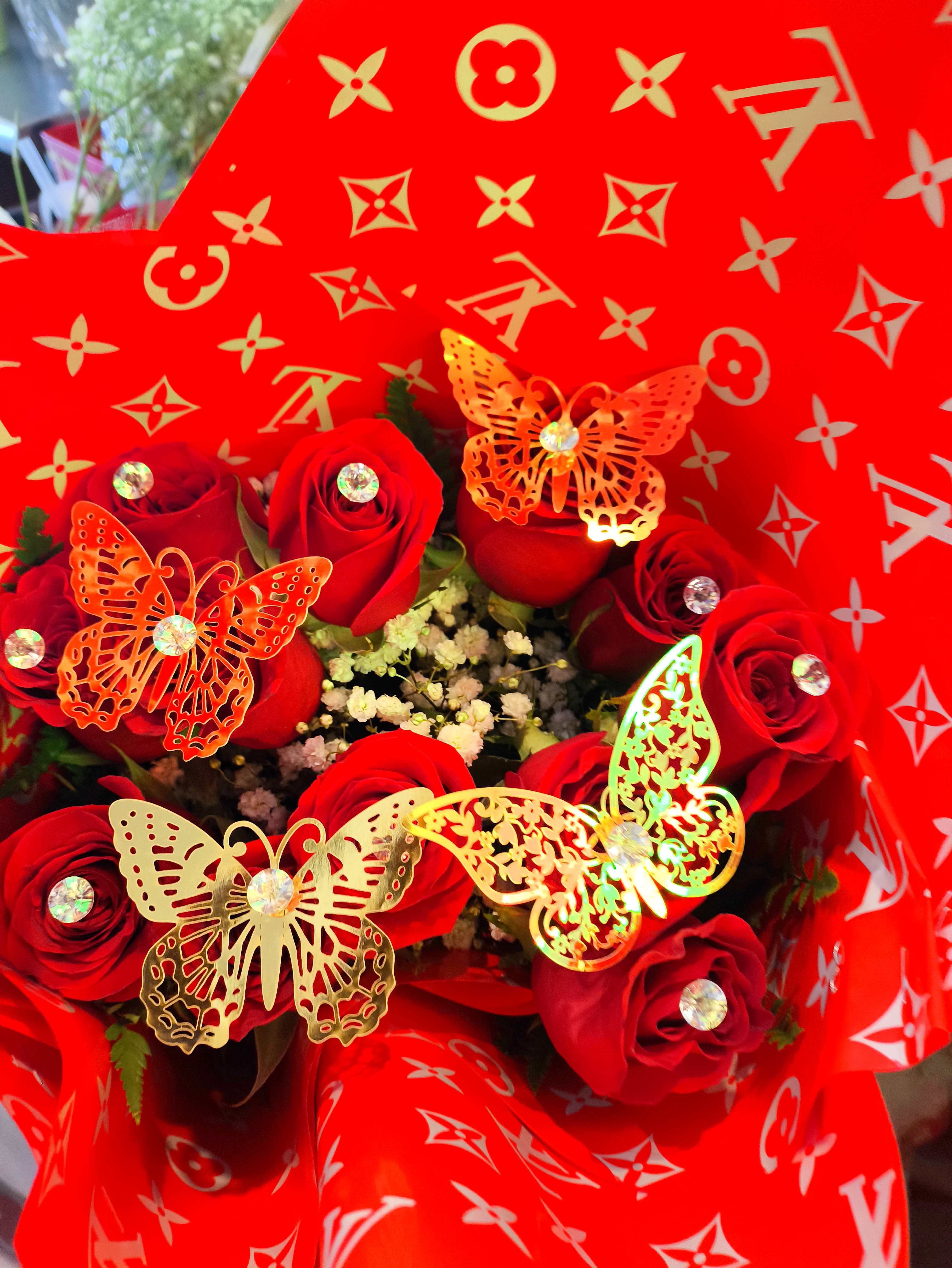 Bouquet of red roses wrapped in bright red patterned paper