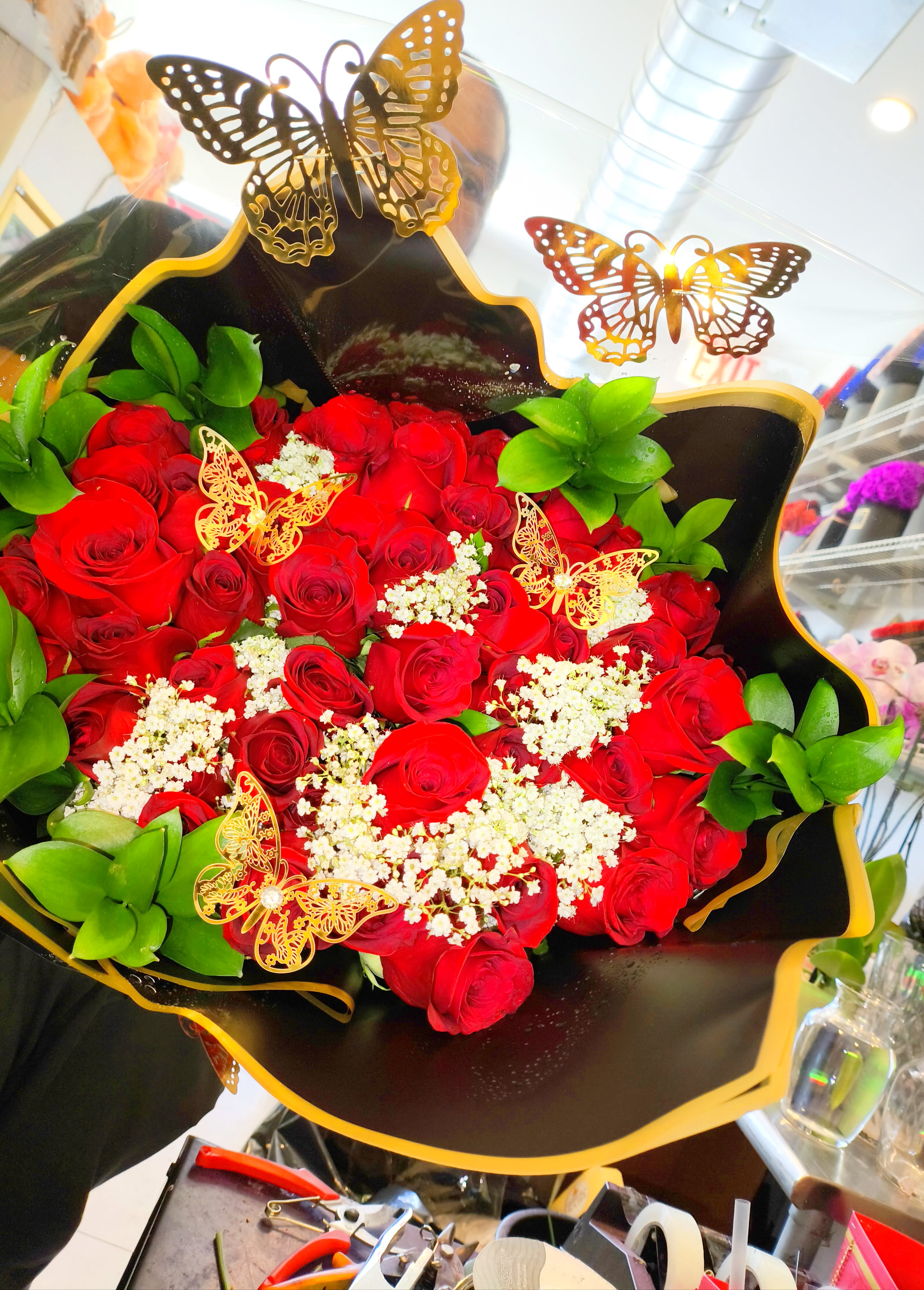 Bouquet of red roses with white filler and butterfly decorations