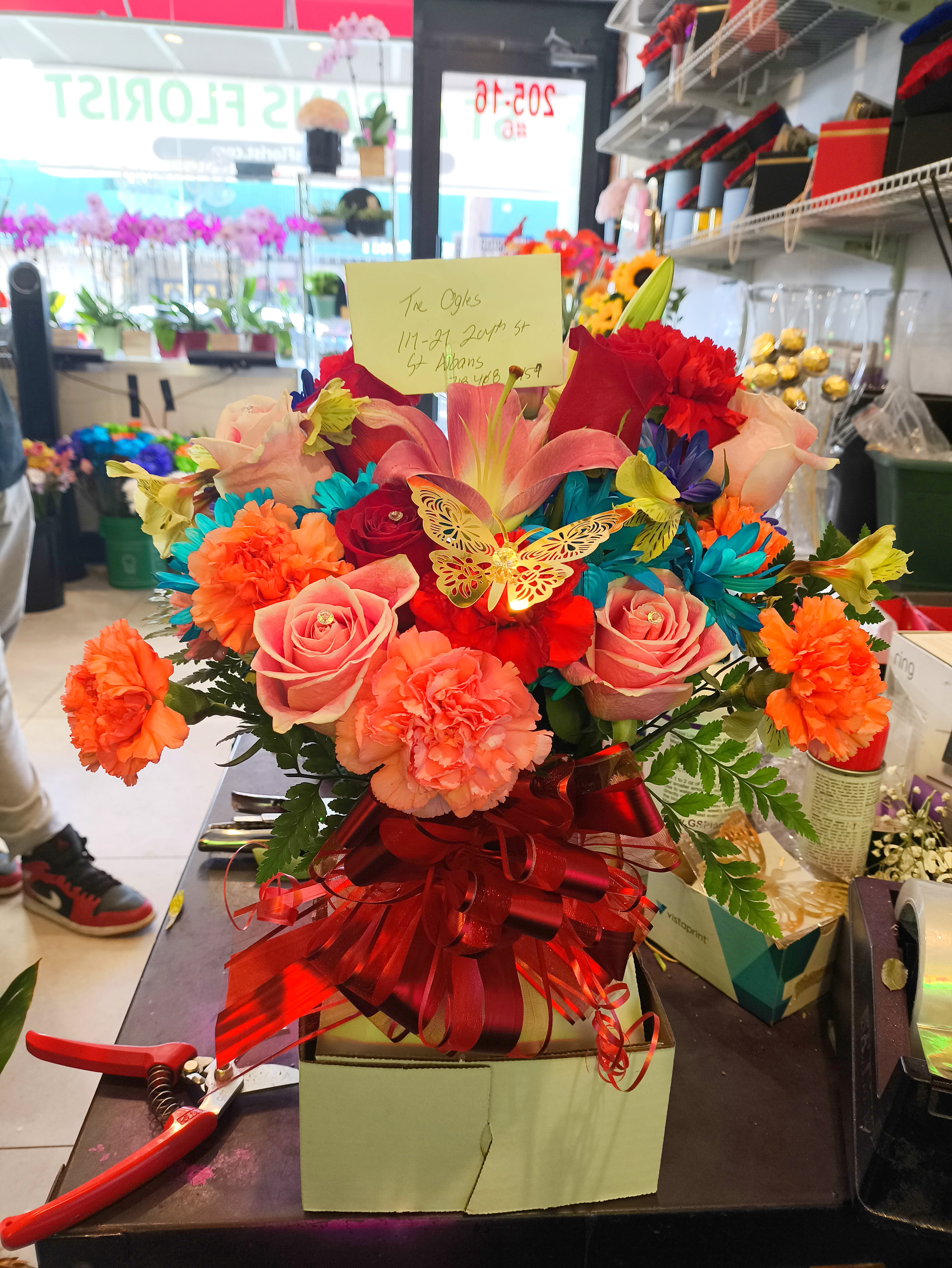 Bright mixed bouquet with roses, lilies, and carnations in a gift box