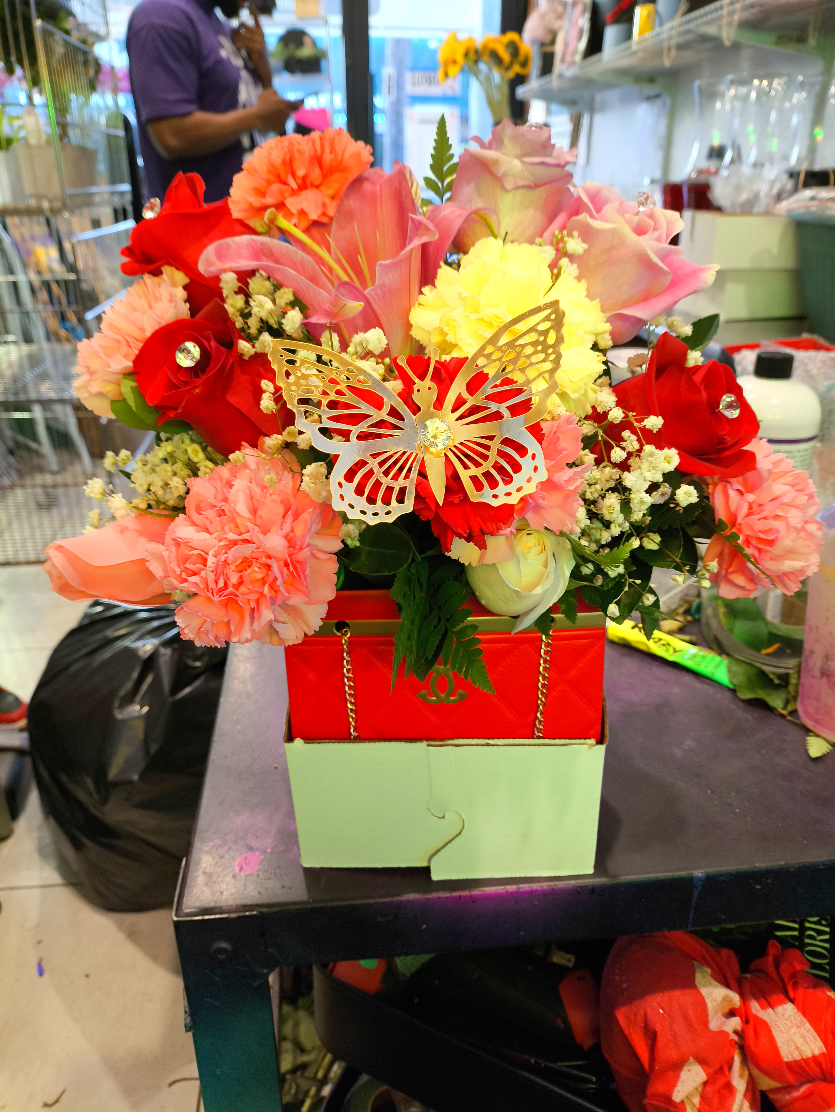 Bright mixed bouquet with roses, lilies, and carnations in a red box