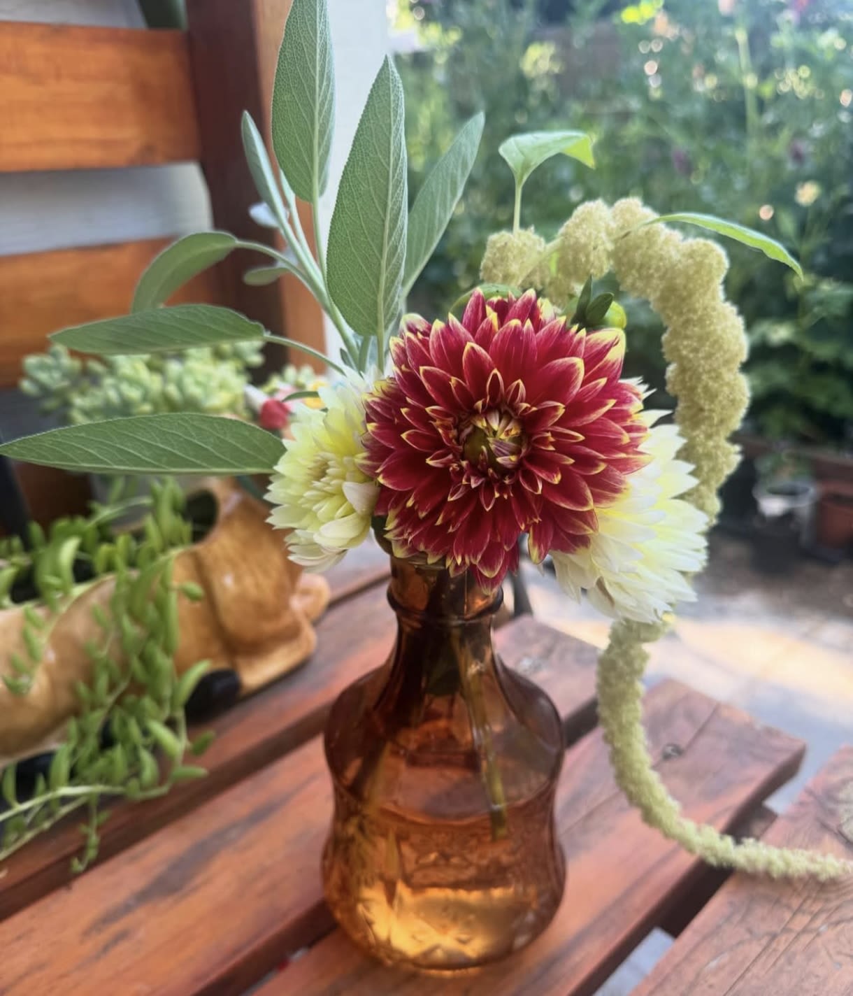 Dahlia bouquet in an amber glass vase with tall greenery