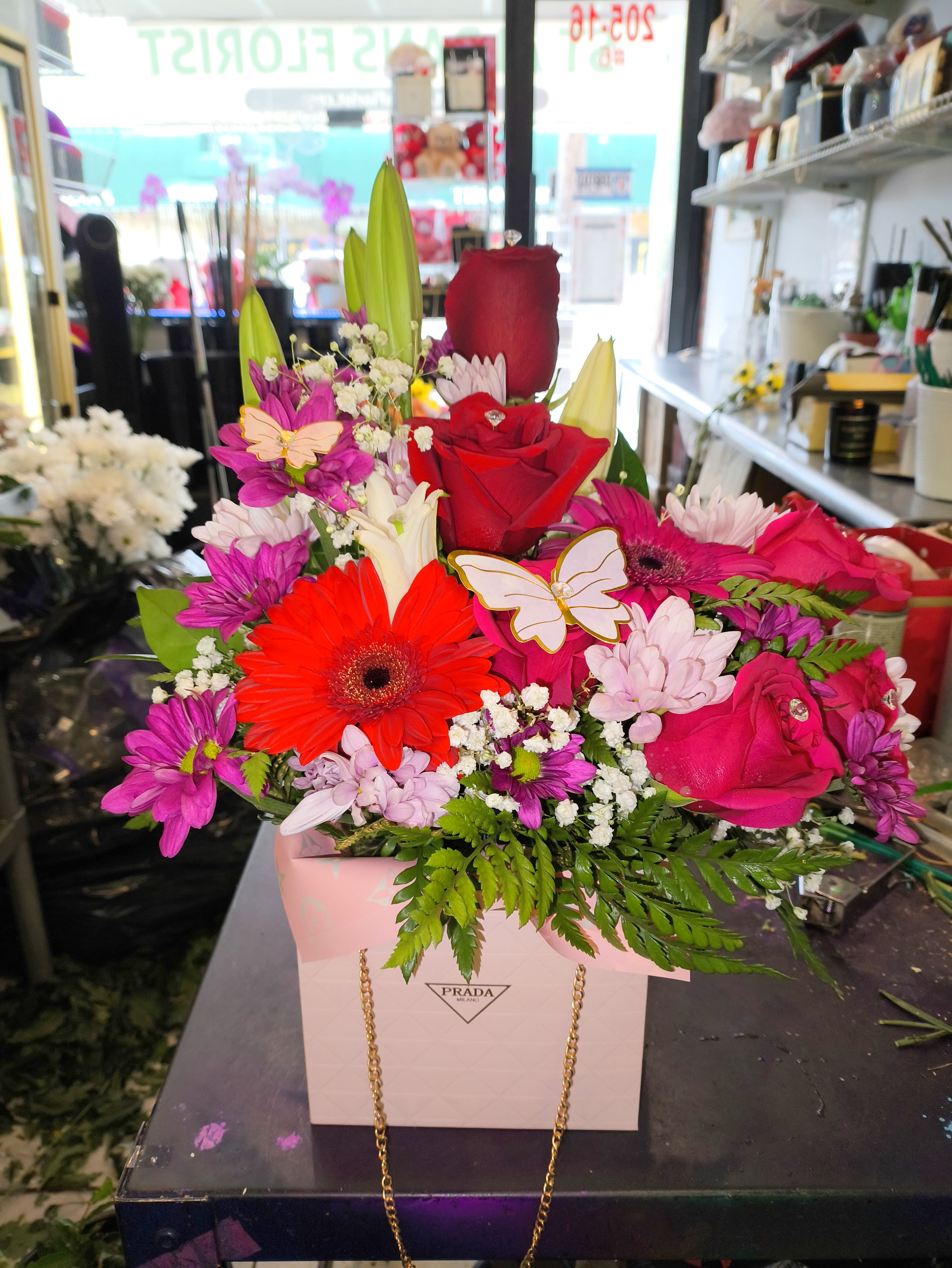 Bright mixed bouquet in a pink gift bag with roses and daisies