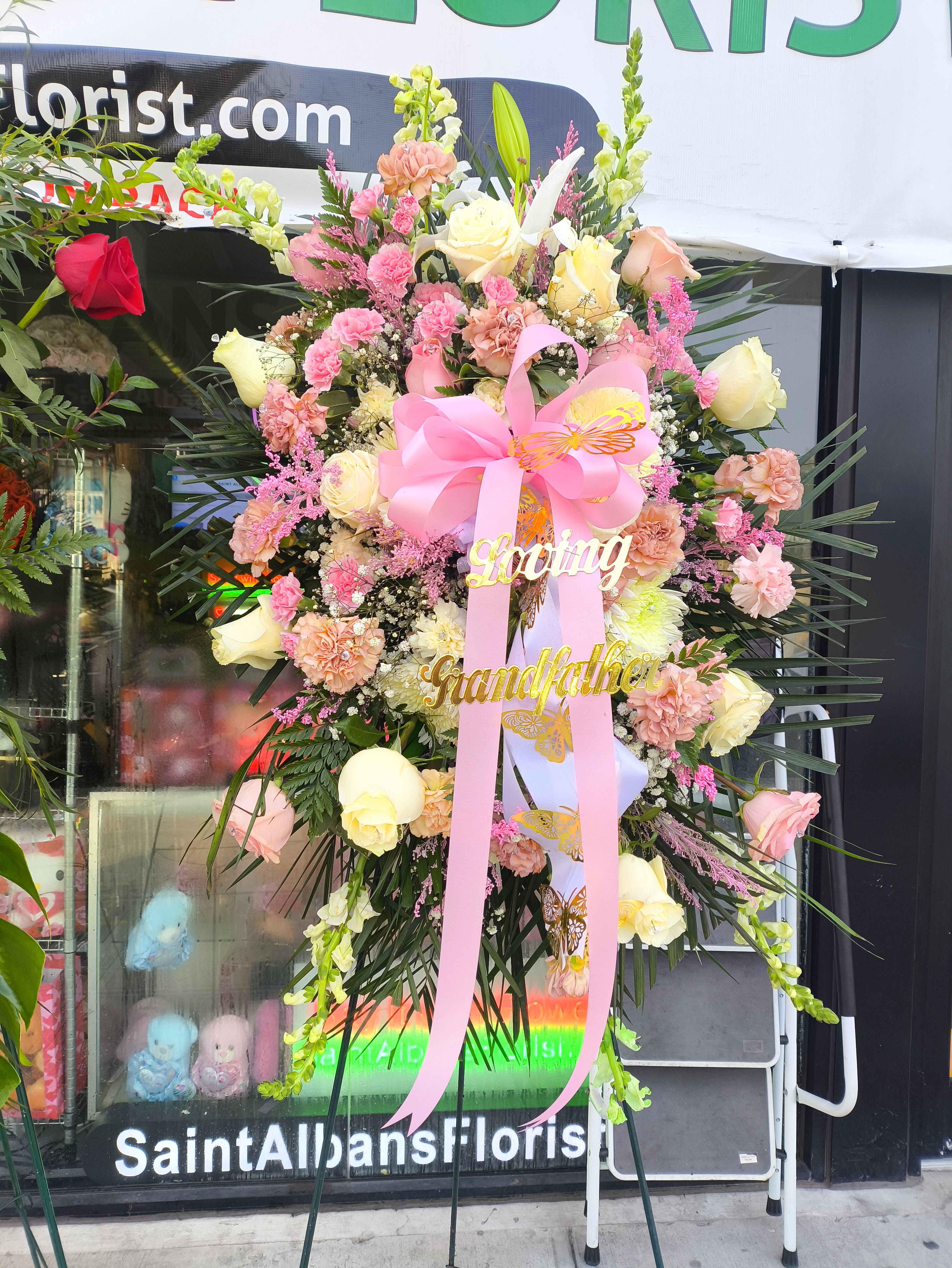 Large pink and cream floral standing spray with ribbon and name accents