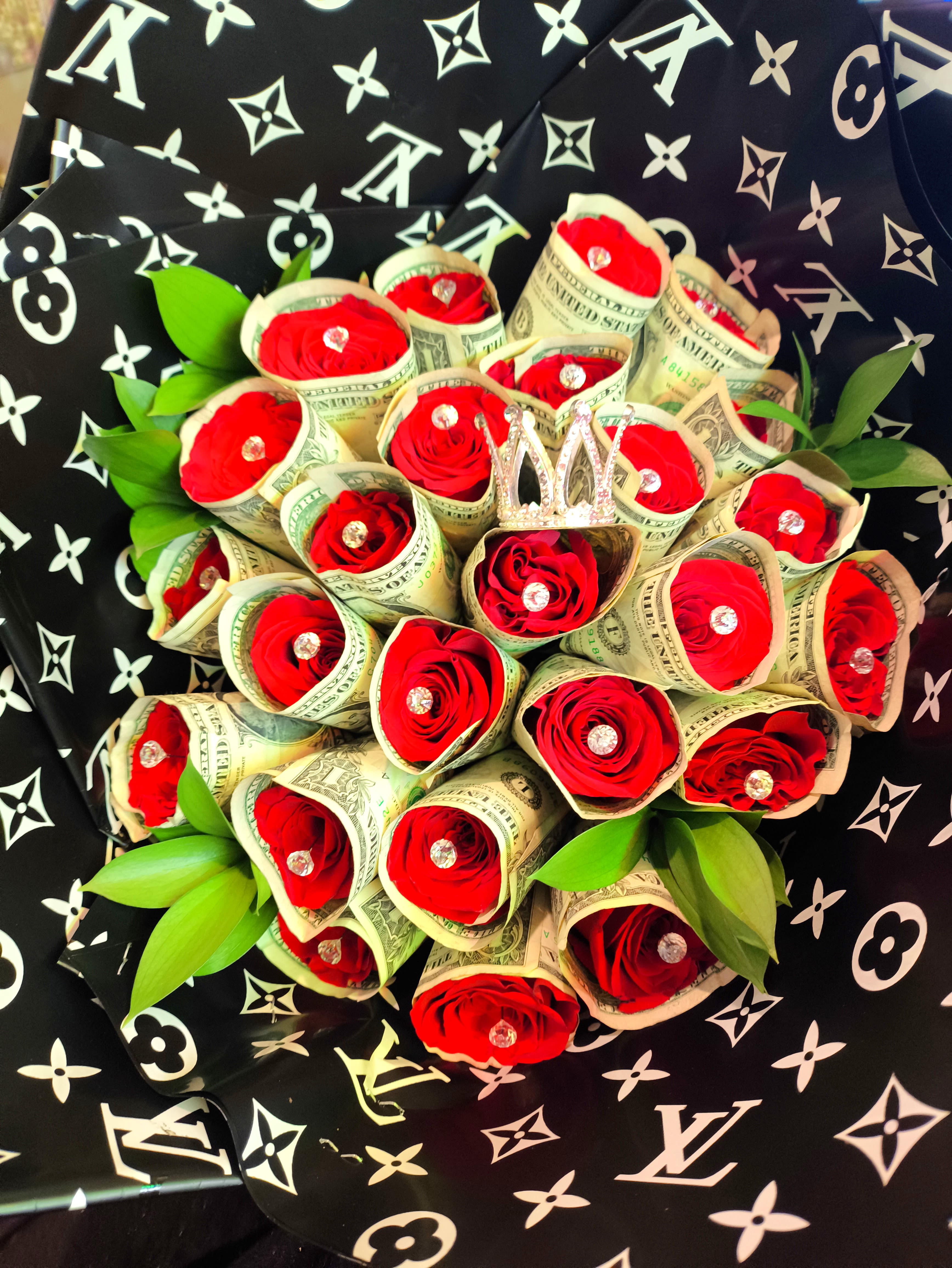 Bouquet of red roses wrapped in dollar bills with green leaves