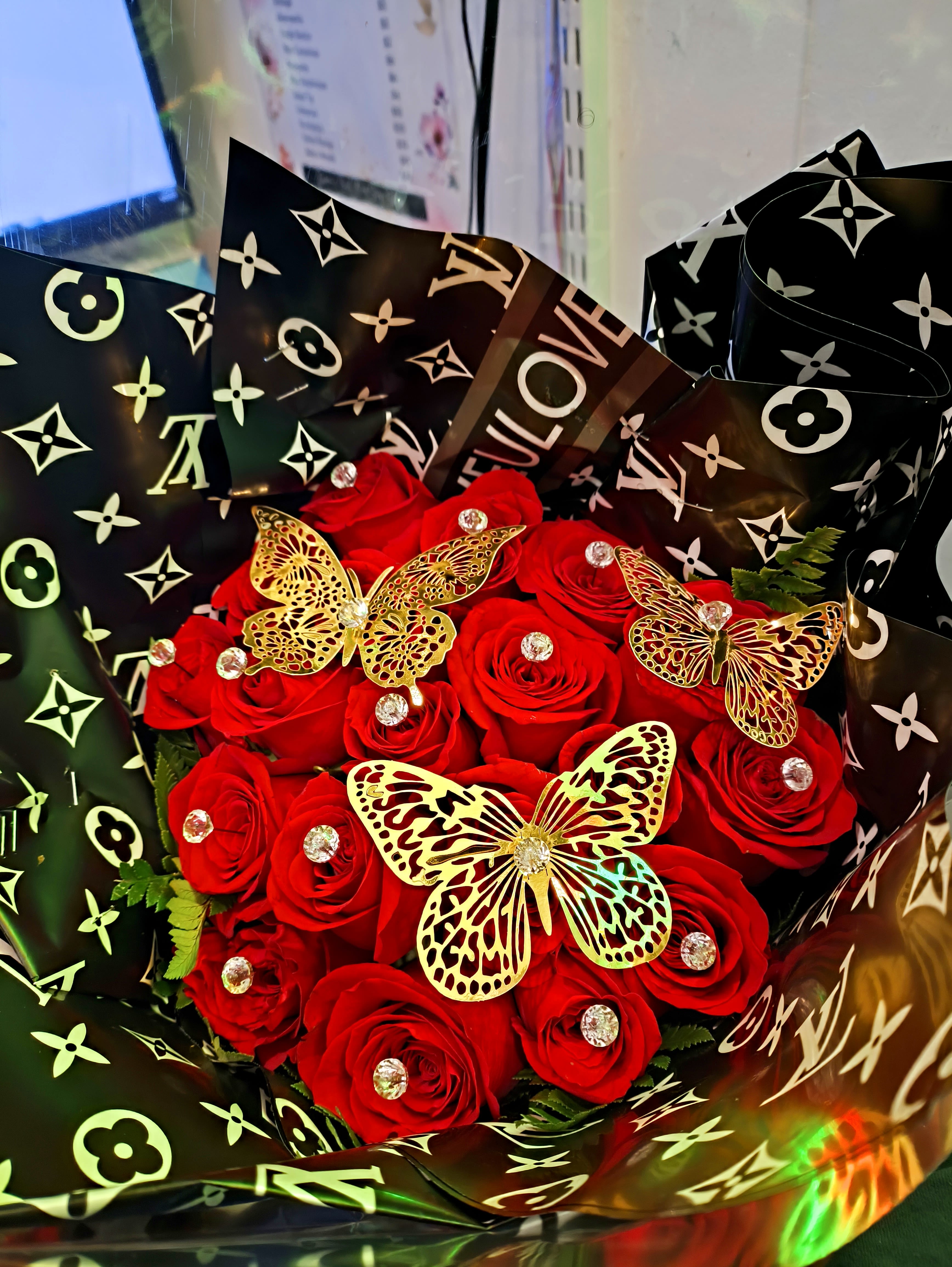 18 Red Roses with Designer Wrapping  - Designer wrapping with 18 red roses and gold butterflies and diamonds with a big red or gold bow. 